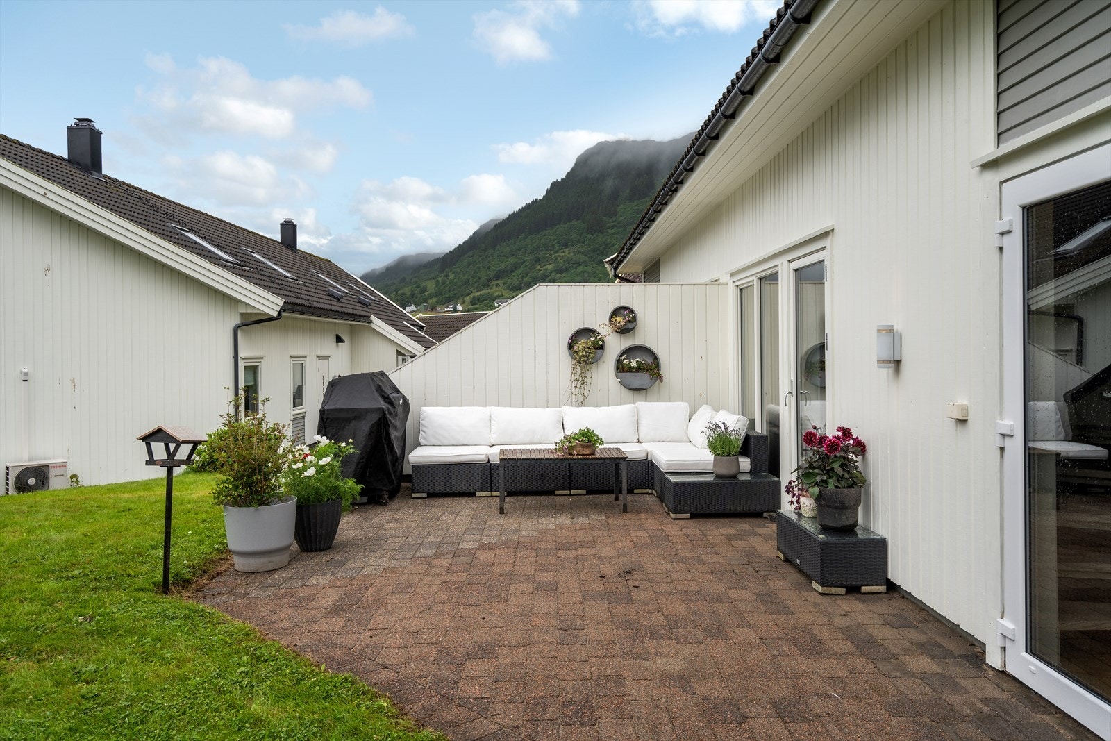 Romslig, steinbelagt uteplass med god plass til utemøbler og grill. Galleribilde