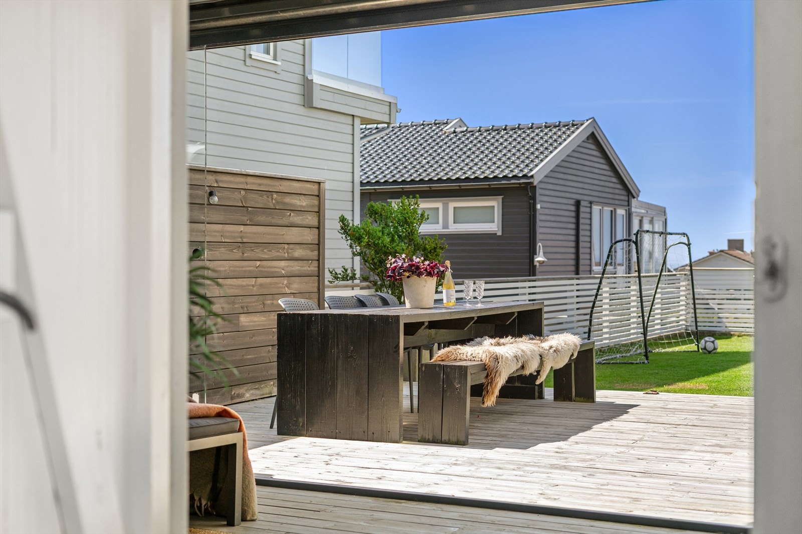 Fra stuen åpner dørene seg mot en stor terrasse og hage. Galleribilde