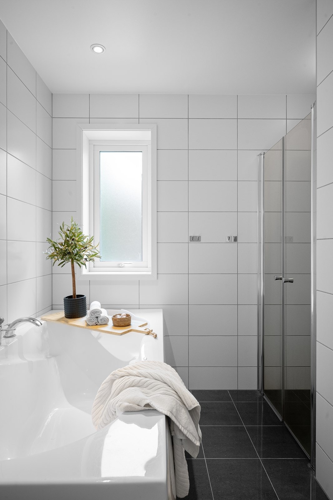Badet har flislagt gulv med gulvvarme og spotter i taket. Galleribilde