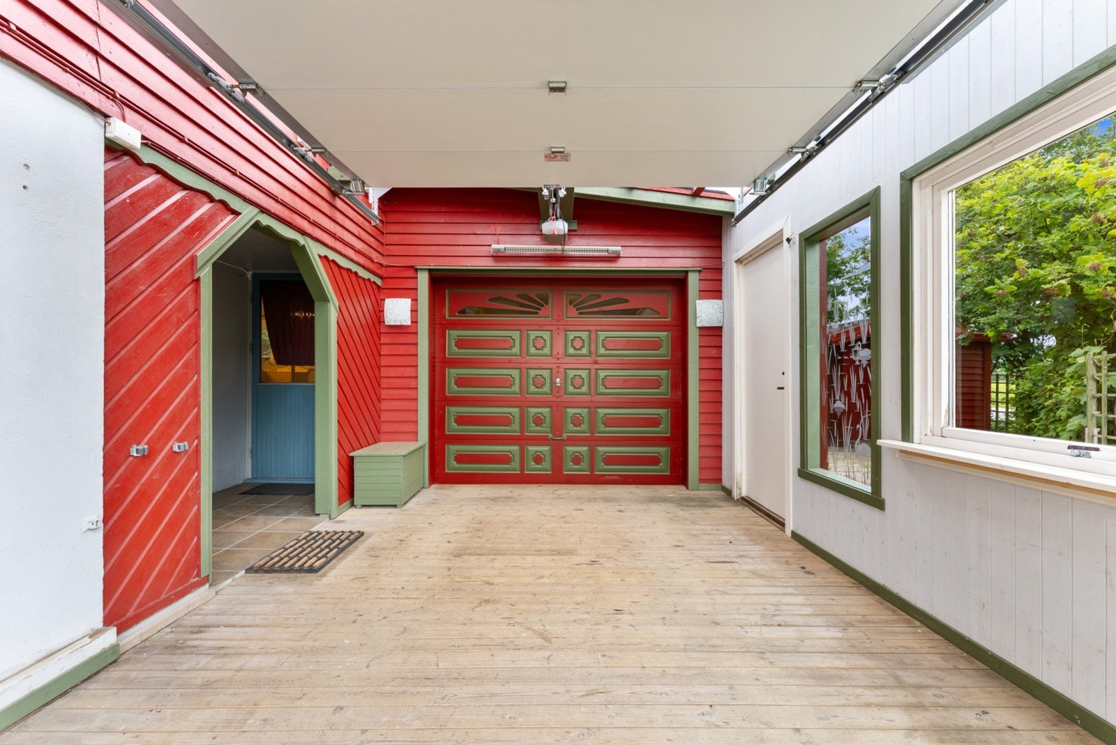 Carporten har tregulv og gir ly for bilen. Galleribilde