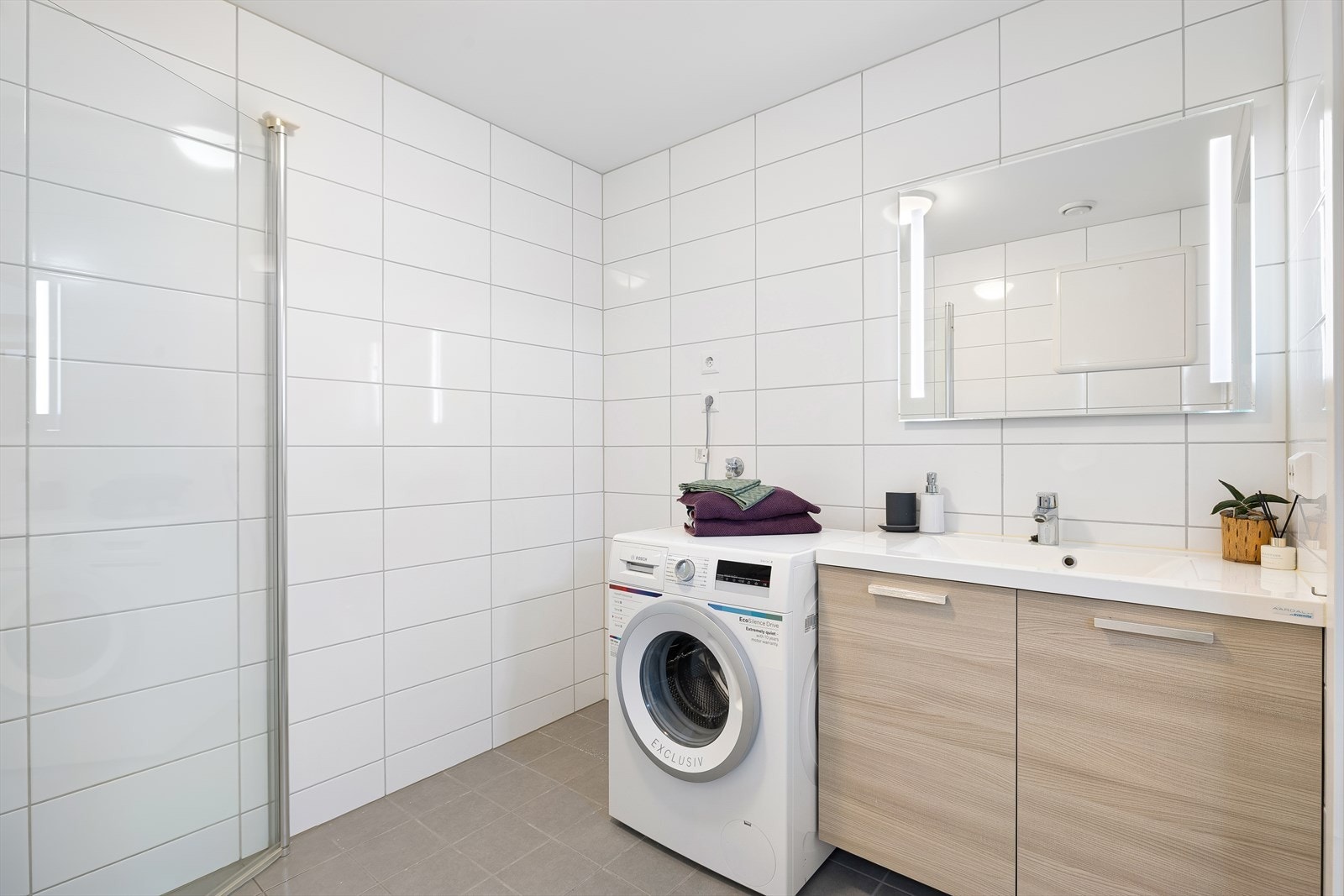Fra entréen har man tilgang til et praktisk utformet og pent baderom på ca. 4,7 kvm, med opplegg for vaskemaskin. Galleribilde
