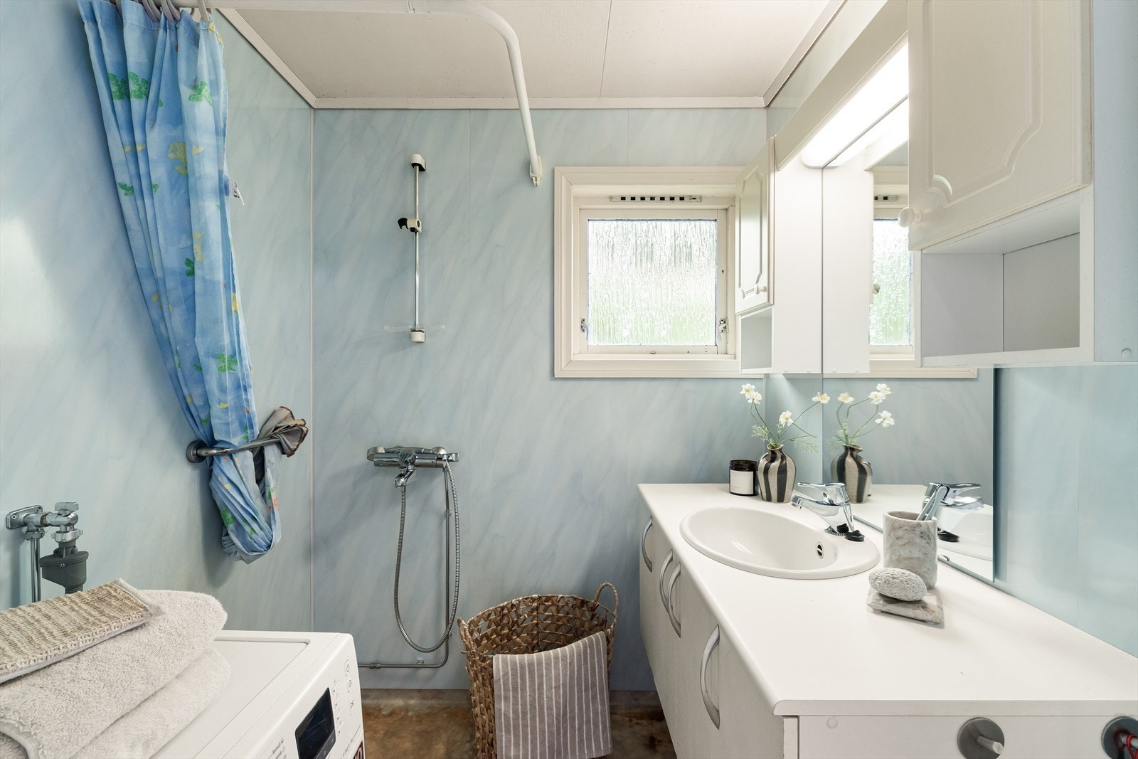 Badet har belegg på gulv og baderomsplater på veggene. Rommet er vegg i vegg med toalettrommet. Galleribilde