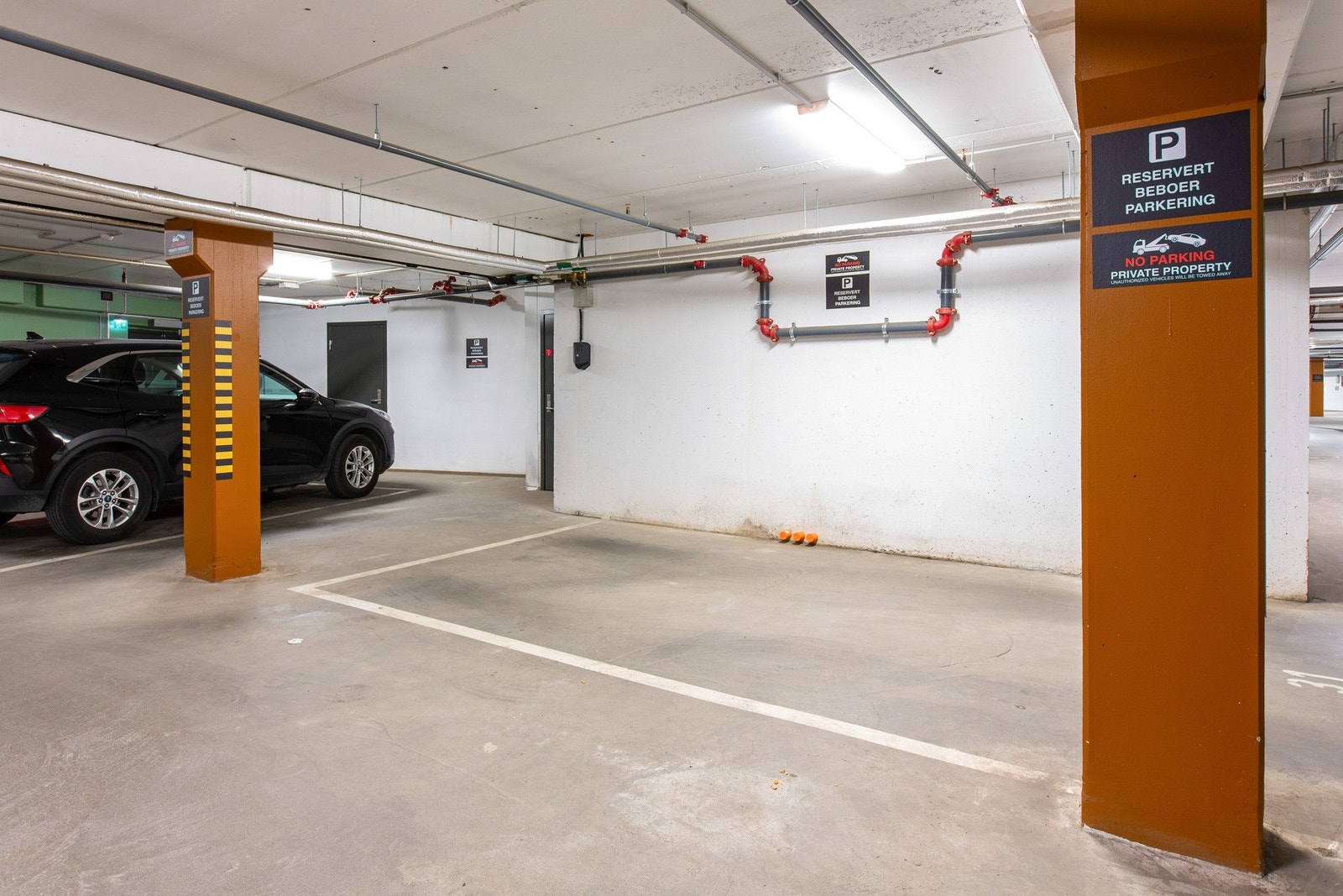 Selger disponerer biloppstillingsplass i kjeller med el-billader. Galleribilde