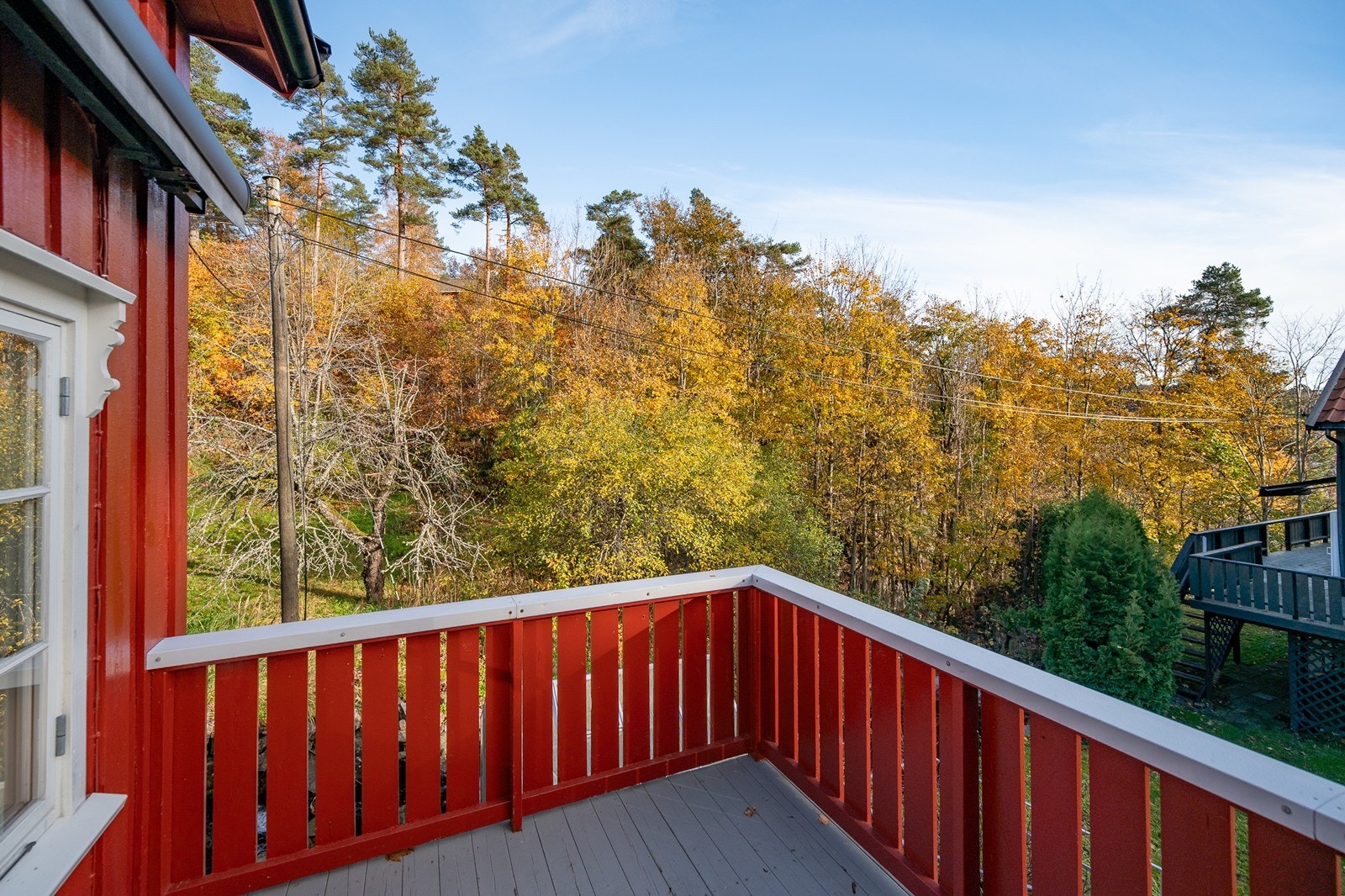 Terrassen har dekke av terrassebord og rekkverk Galleribilde