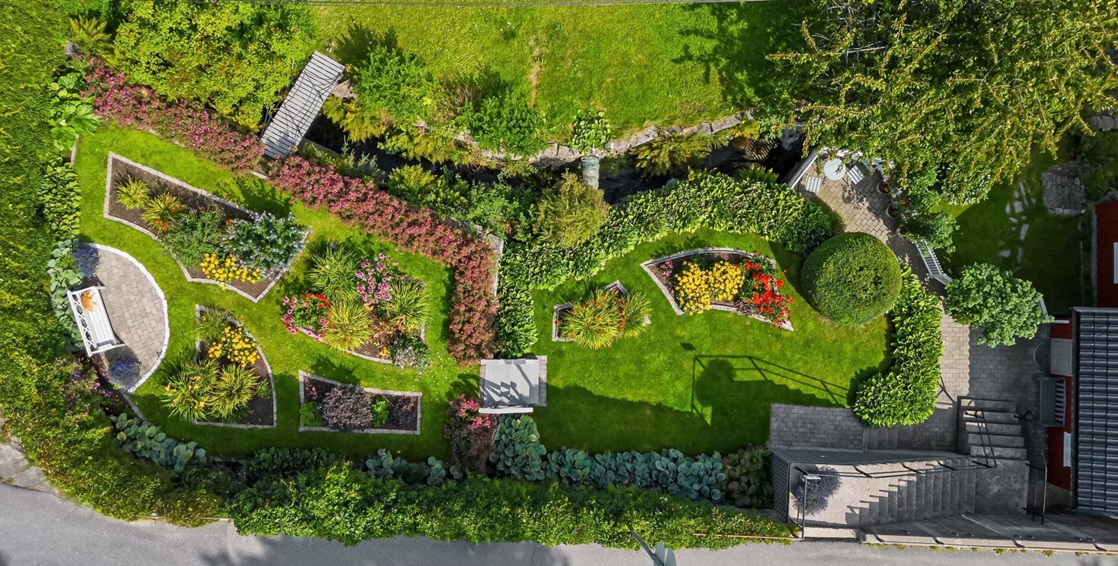 Tomten har en strukturert layout med gangveier og grøntarealer. Galleribilde
