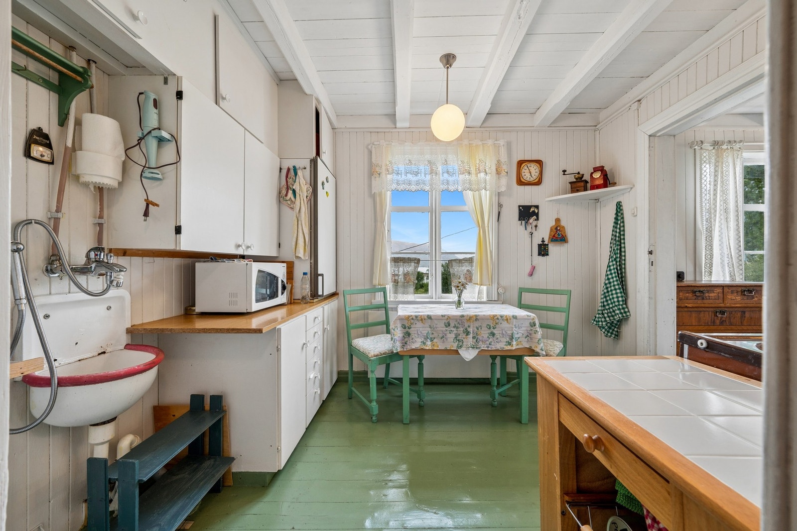 Kjøkkenet har en sjarmerende, eldre stil med spiseplass ved vinduet. Galleribilde