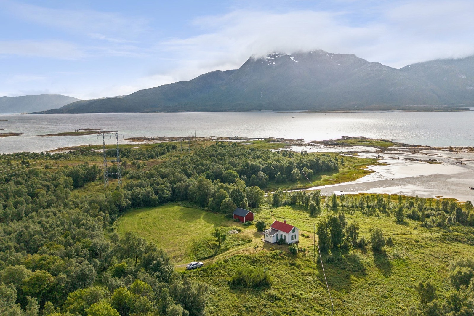 Eiendommen sett fra luften, med fjorden og fjellene som ramme. Galleribilde