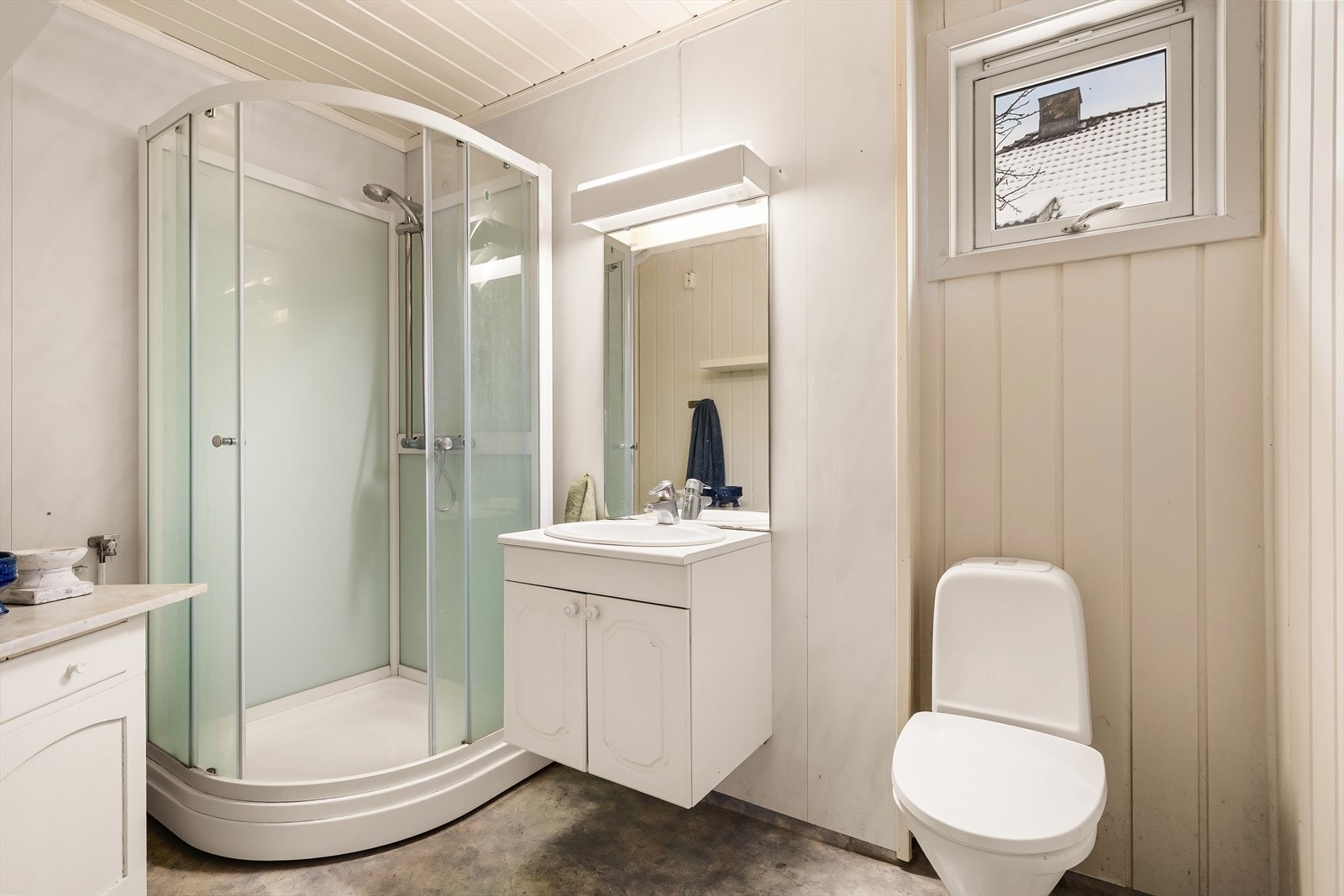 Badet har vinylbelegg på gulv, dusjkabinett og opplegg for vaskemaskin. Galleribilde