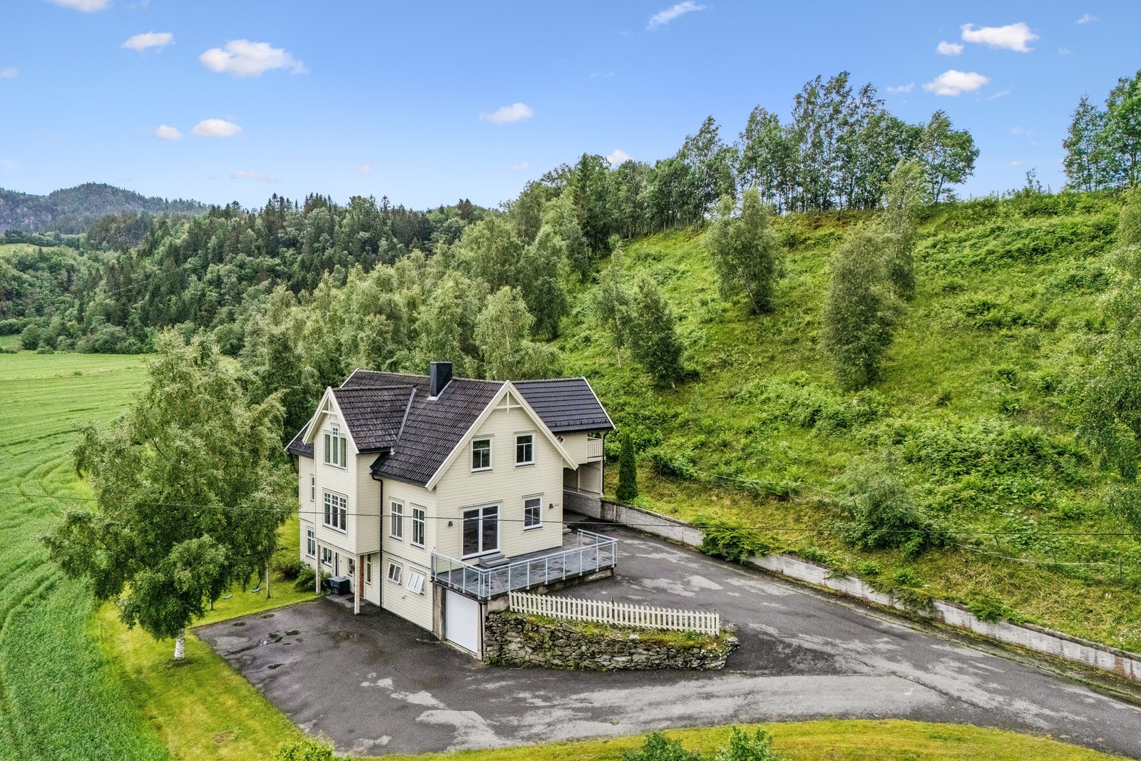 God plass til parkering rett utenfor huset, samt i integrert garasje på nedsiden av huset. Galleribilde