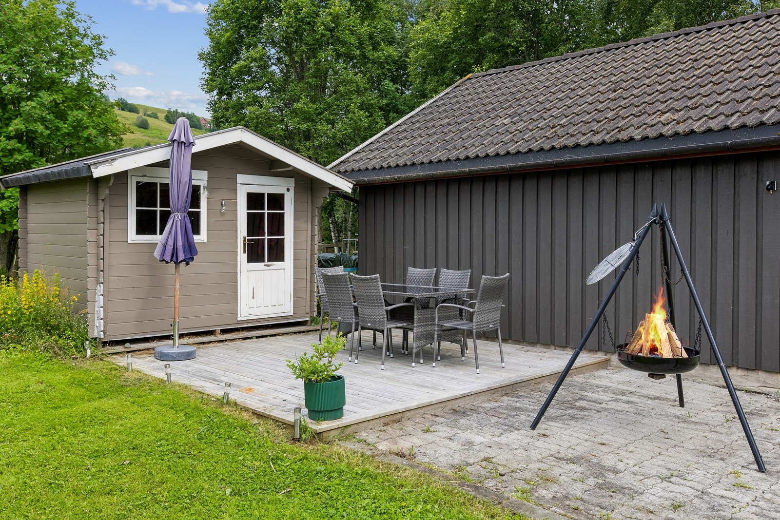 Frittstående utebod med terrasseområde. Galleribilde