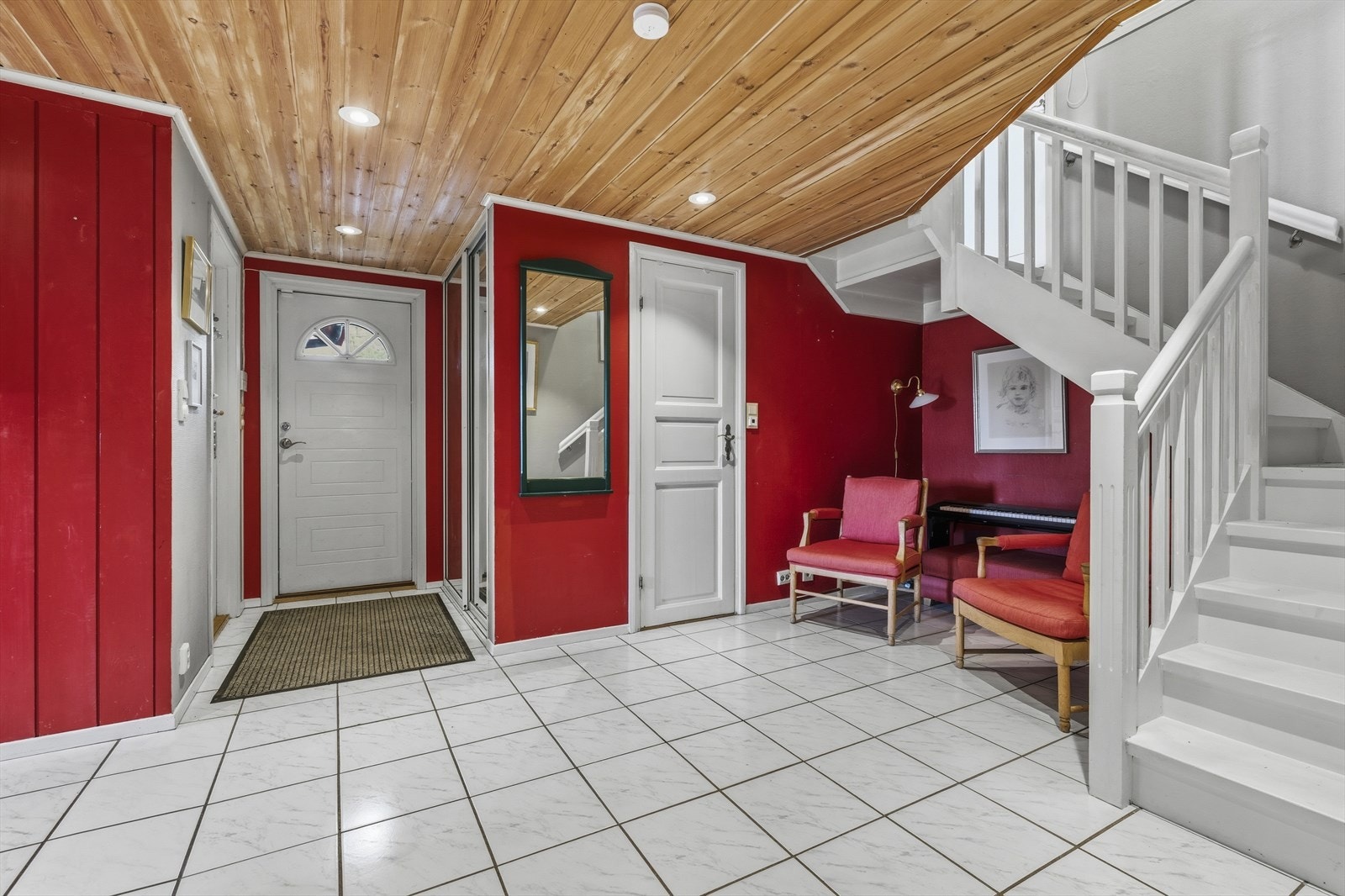 Entré i 1. etasje med flislagt gulv og downlights i himling. Det er praktiske løsninger for oppbevaring av yttertøy og sko i skyvedørsgarderobe med speilfronter Galleribilde