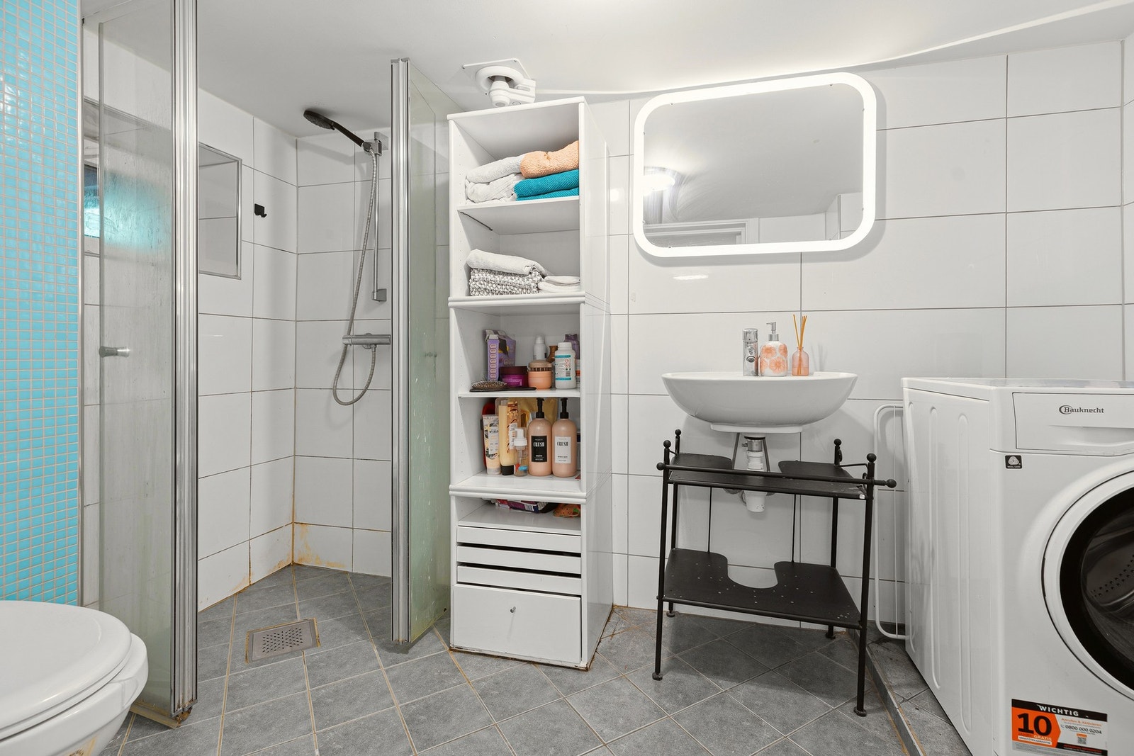 Flislagt bad i underetasjen med opplegg for vaskemaskin Galleribilde