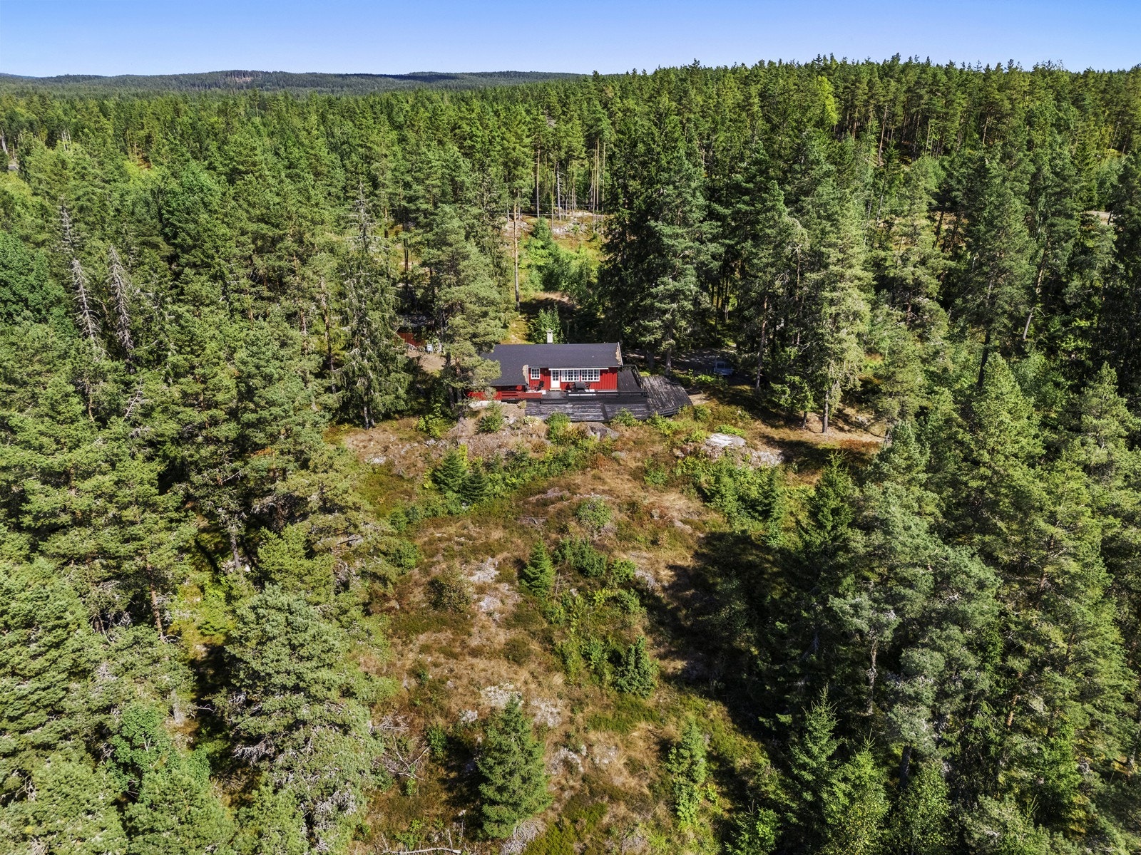Boligen ligger usjenert til, omgitt av skog og vegetasjon. Galleribilde