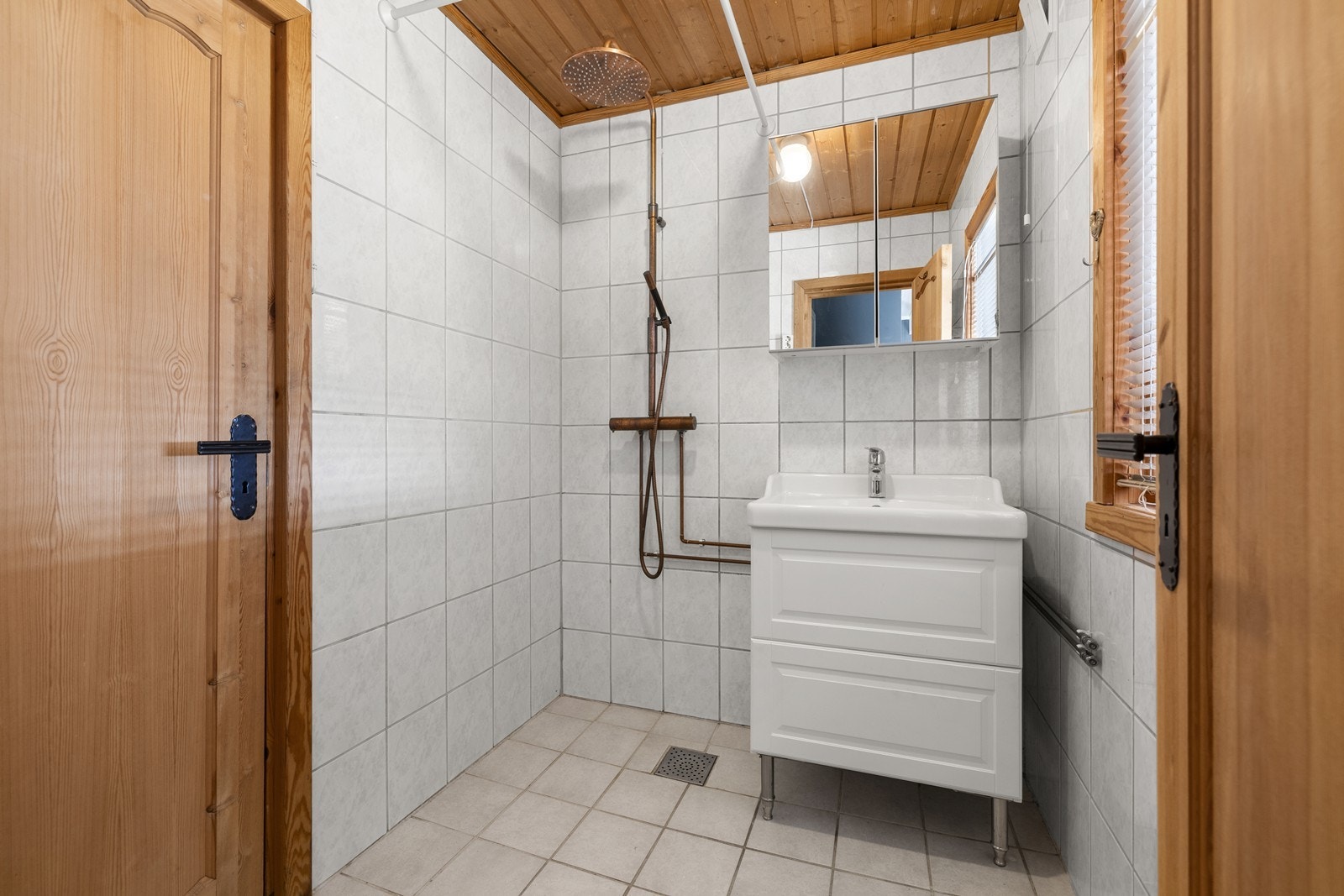 Flislagt bad med varmekabler i gulv, og er innredet med dusj og servant. Badet er funksjonelt i dagens bruk, men har et moderniseringsbehov. Galleribilde