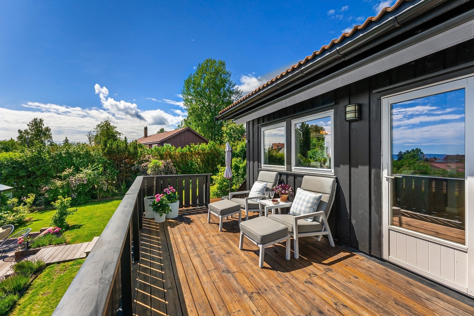 Balkongen har gulv av terrassebord og rekkverk i tre. Galleribilde