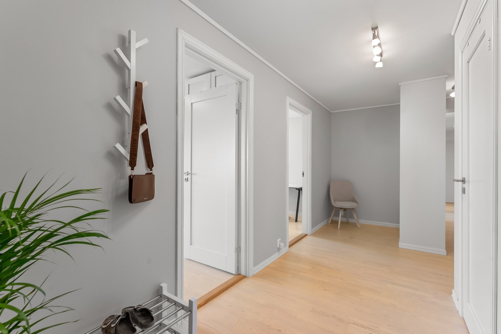 Gang i underetasjen med laminat- og parkettgulv og downlights i himling. Galleribilde