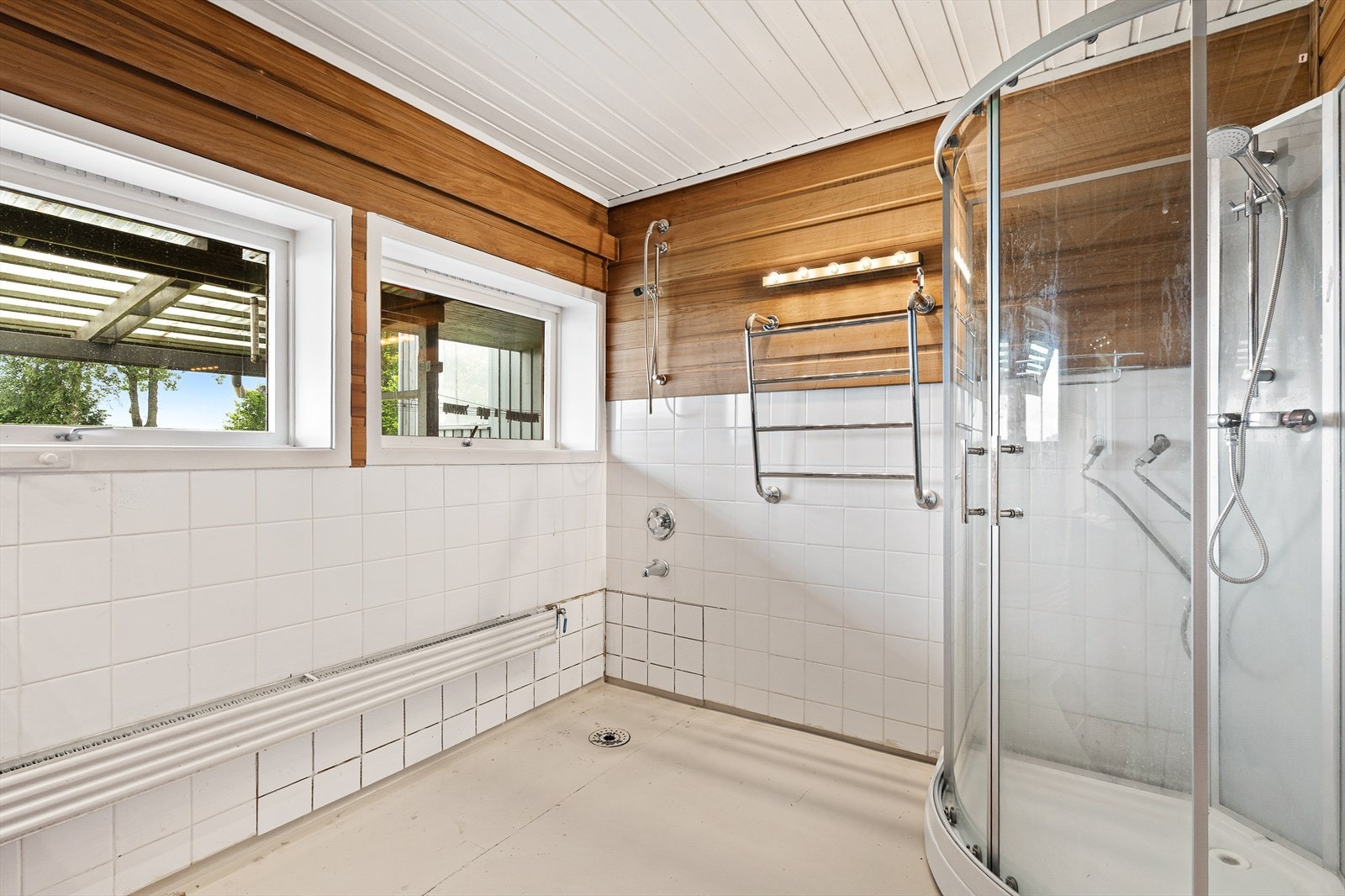 Badet har fliser på deler av veggen og malt vinylbelegg på gulvet. Galleribilde