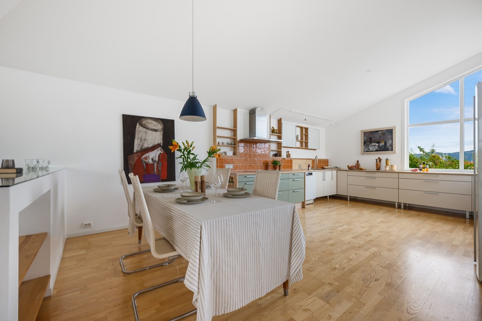 Lyst kjøkken og spisestue i åpen planløsning. Galleribilde