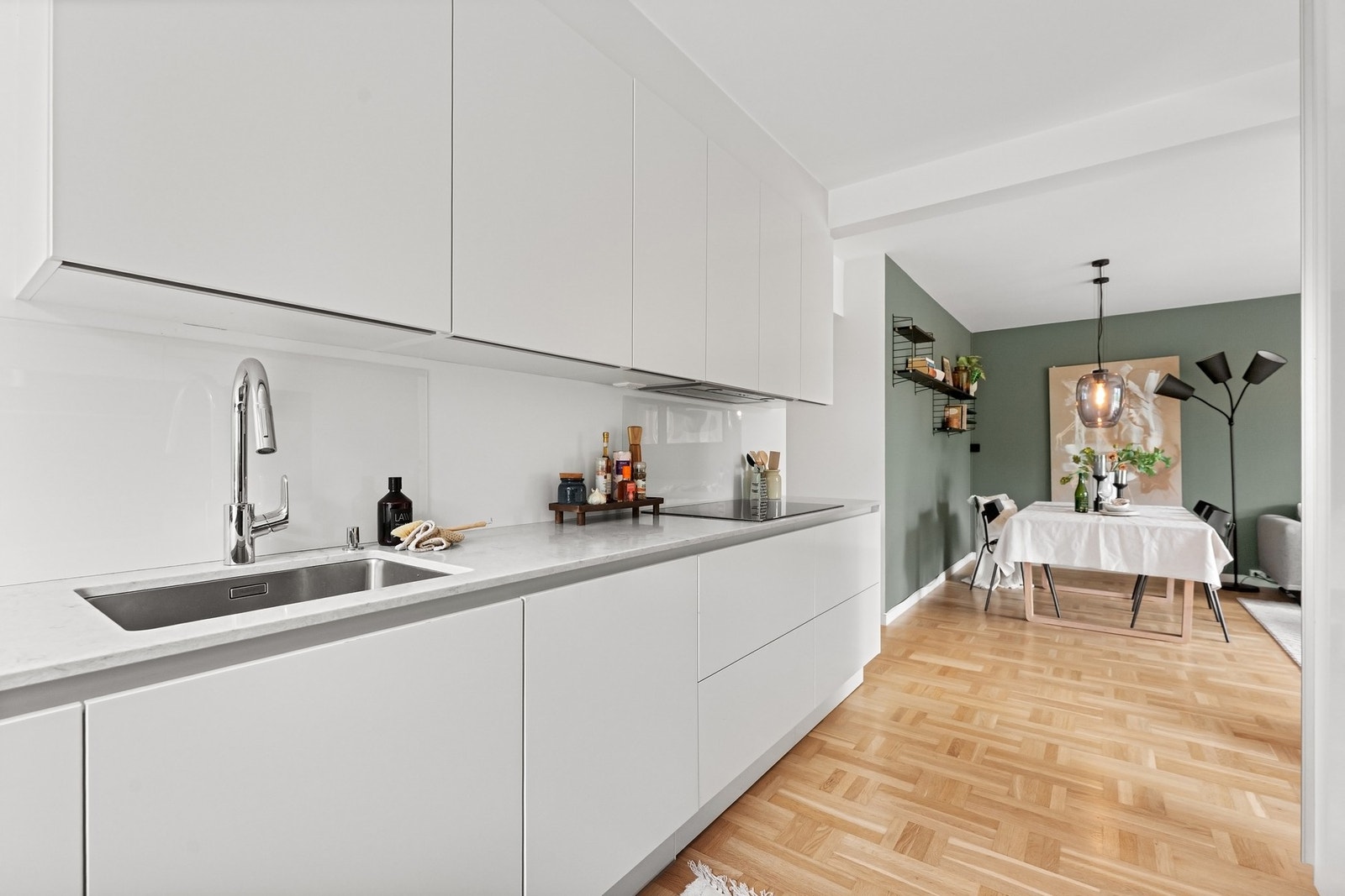 Innredningen har glatte, fabrikklakkerte fronter og en benkeplate med underlimt kum i rustfritt stål. Galleribilde