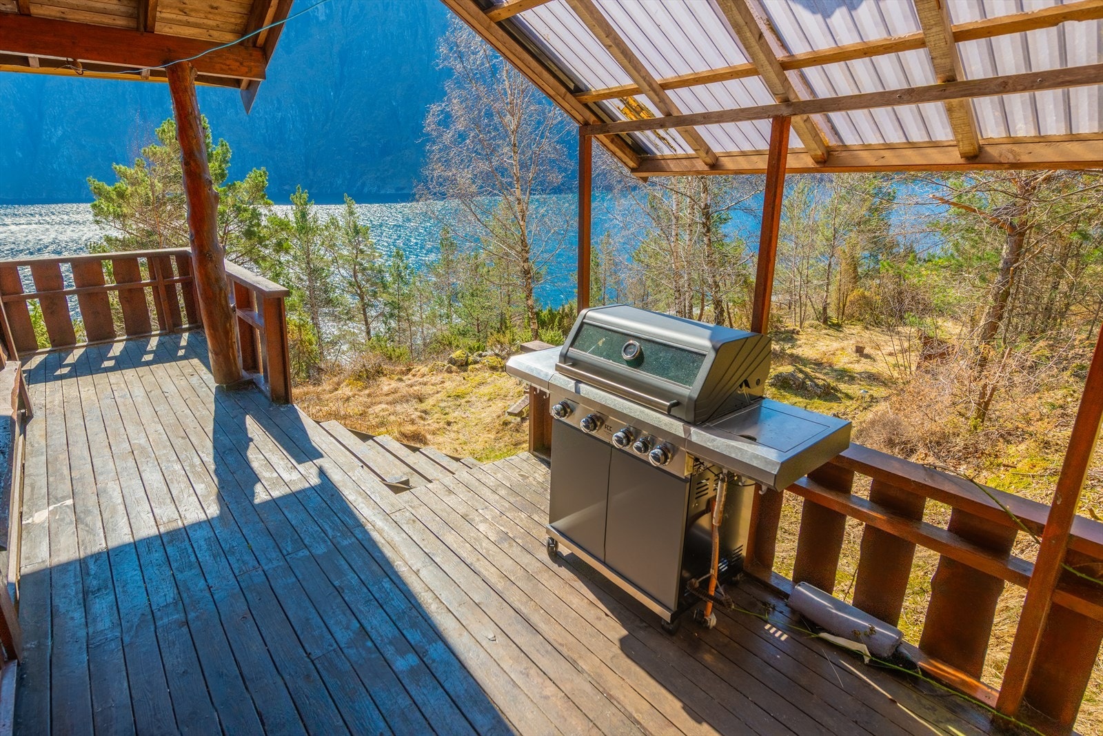 Her kan du sitte ute selv på gråværsdager takket være et overbygd tak. Det gjøres oppmerksom på at grillen ikke medfølger handelen. Galleribilde