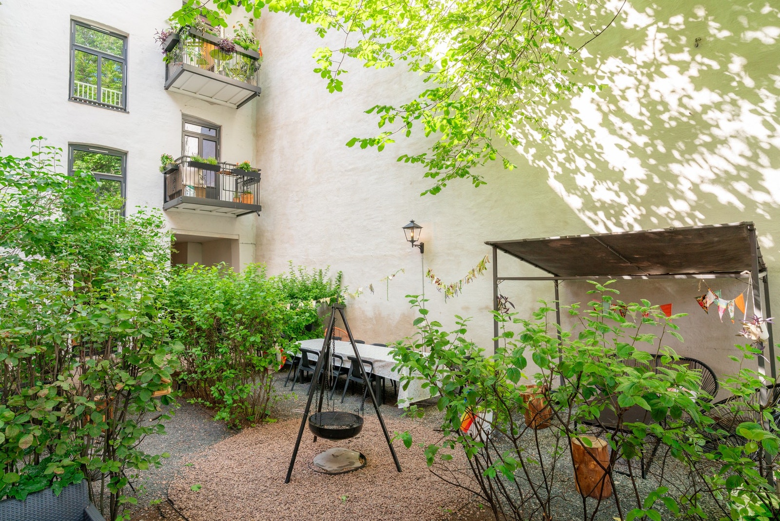 Sameiet har en hyggelig bakgård med sittegrupper, bålpanne og frodig beplantning. Galleribilde
