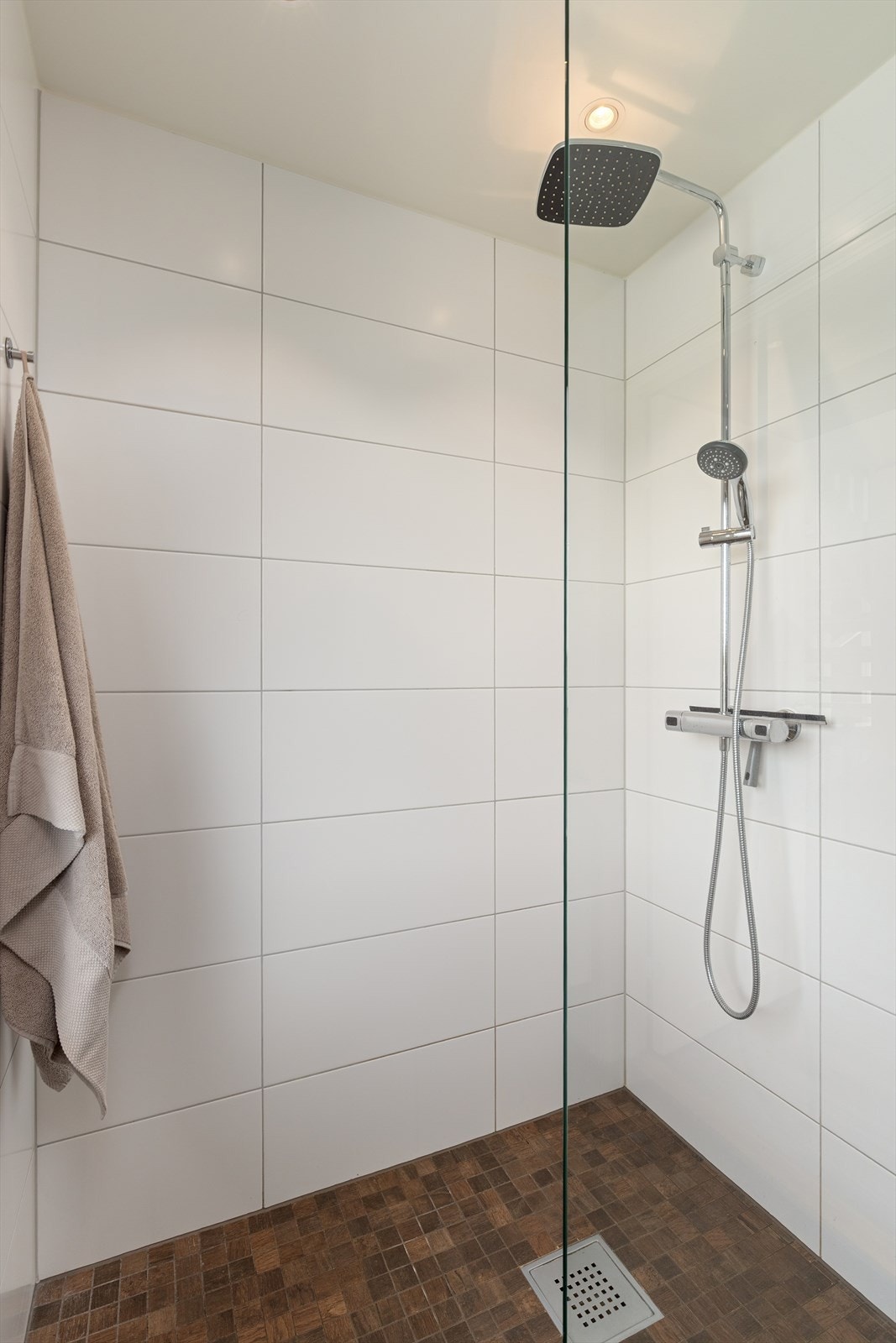 Badet er innredet med gulvstående toalett, servantmøblement og dusjhjørne Galleribilde
