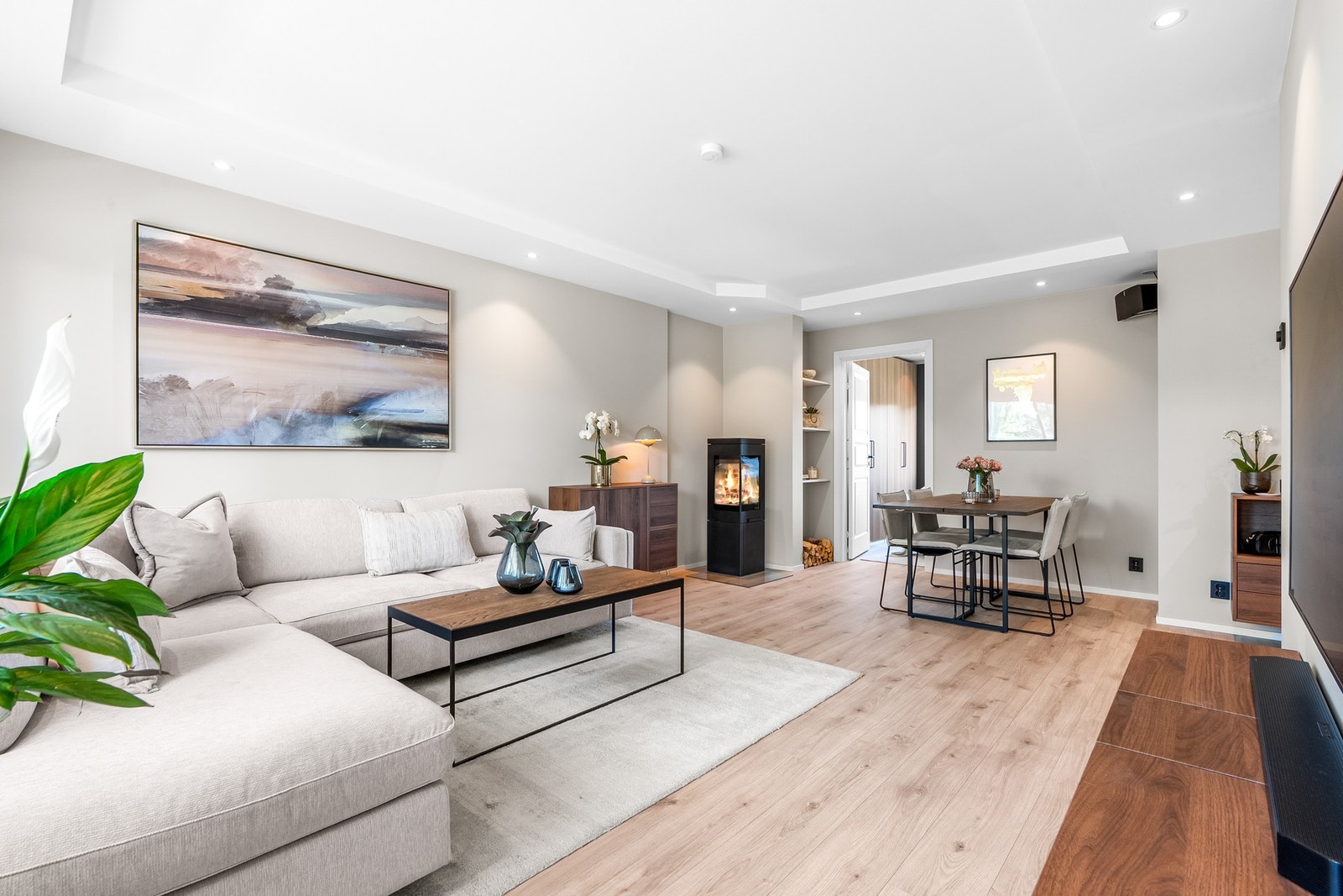 På kveldstid settes stemningen med downlights i himlingen og fyr i en moderne peisovn. Det er installert Plejd smartstyring for alt av belysning i leiligheten. Galleribilde