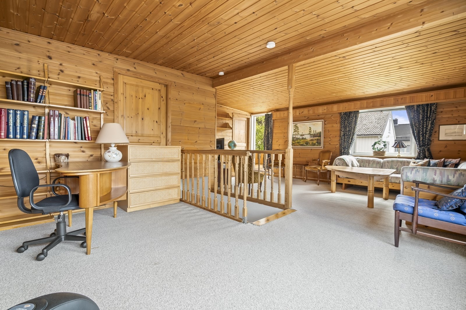Stuen i andre etasje har gjennomgående trepanel på vegger og i tak, med vegg-til-vegg teppe på gulvet. Galleribilde
