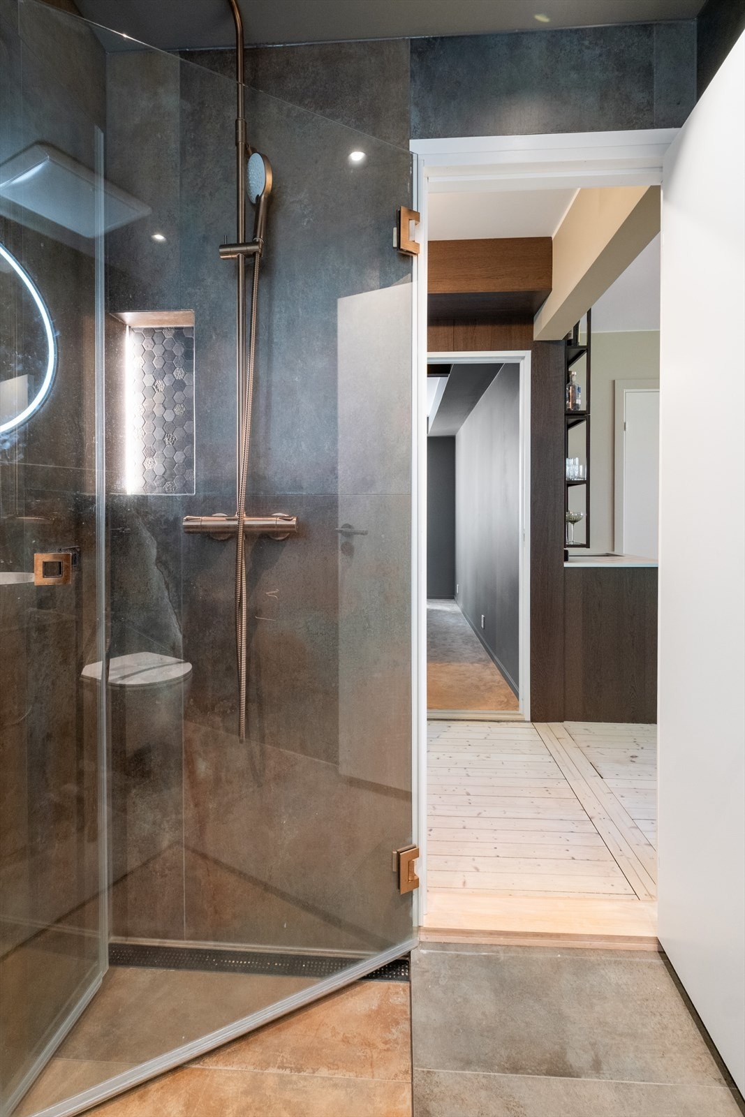 Badet er utstyrt med innfellbare dusjdører i glass og vegghengt toalett Galleribilde