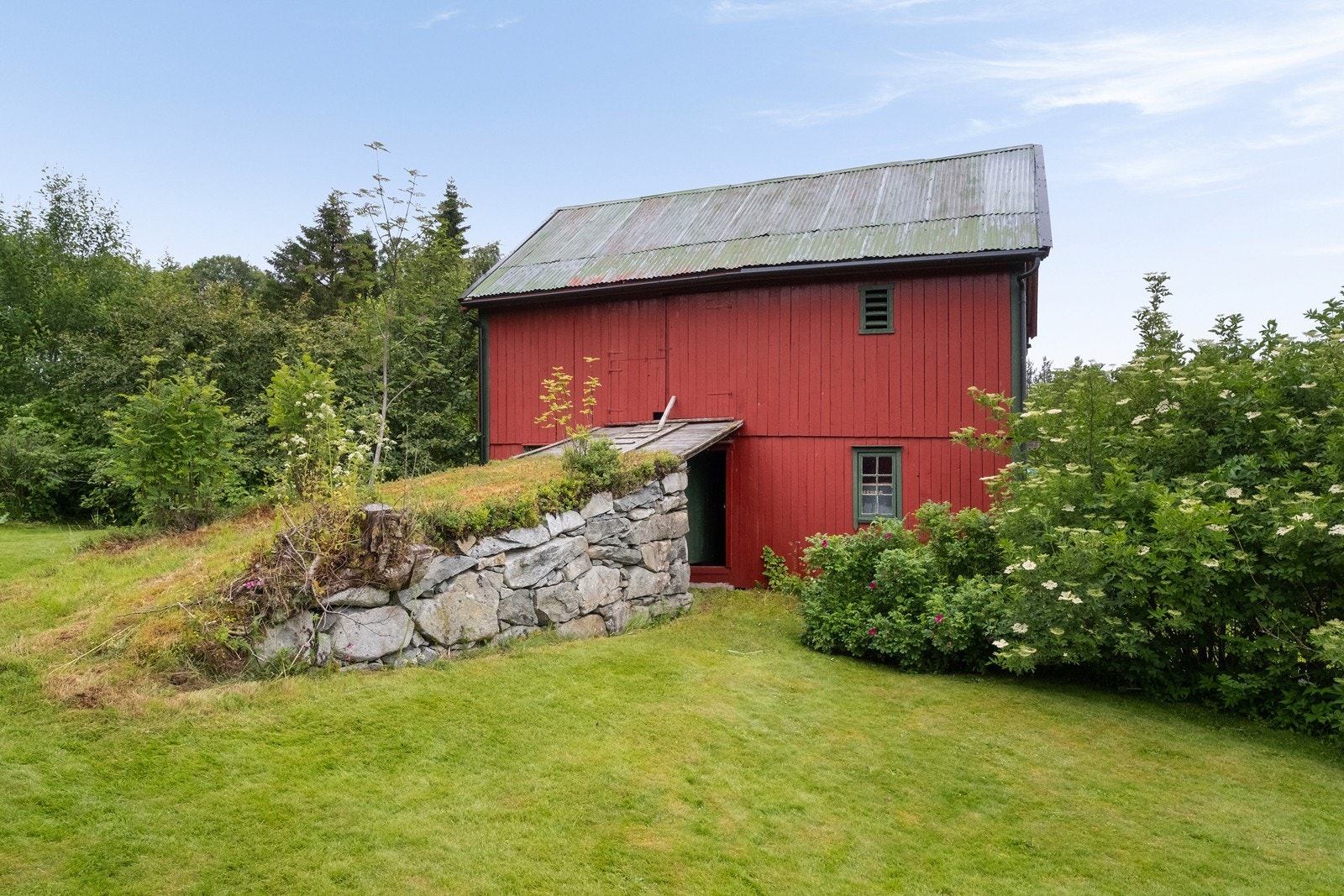 Låven er oppført med støpt betongplate og stående trepanel. Galleribilde