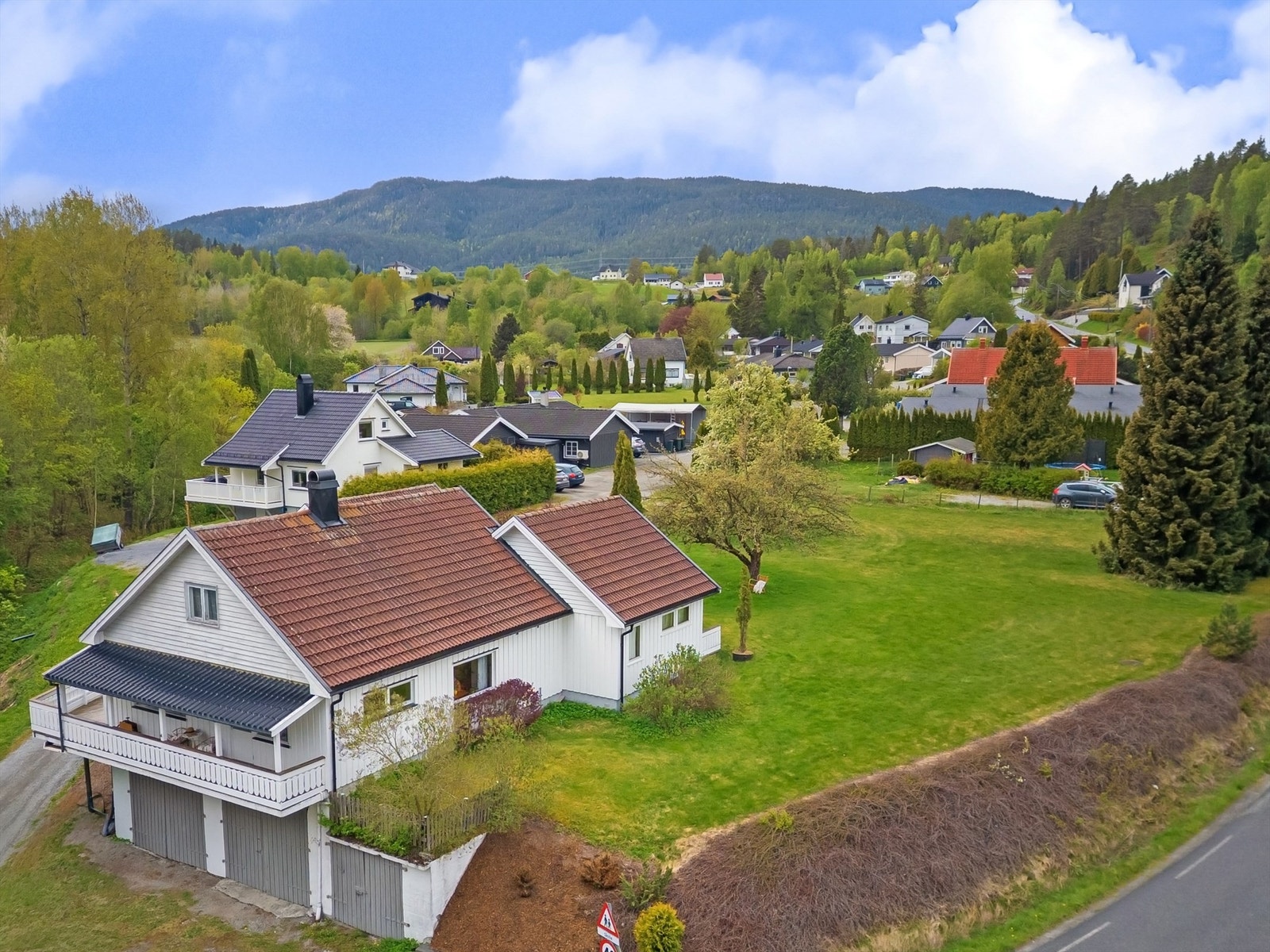 Bingsveien 39 - Enebolig med store garasje i kjeller (ca 3 meter høyde på to av tre plasser) og uthus/sidebygning. I tillegg følger Hellerudveien 19 - boligtomt på ca 2,7 mål som grenser til eiendommen. Foto: Emotional Landscape Production Ole Thoresen Galleribilde