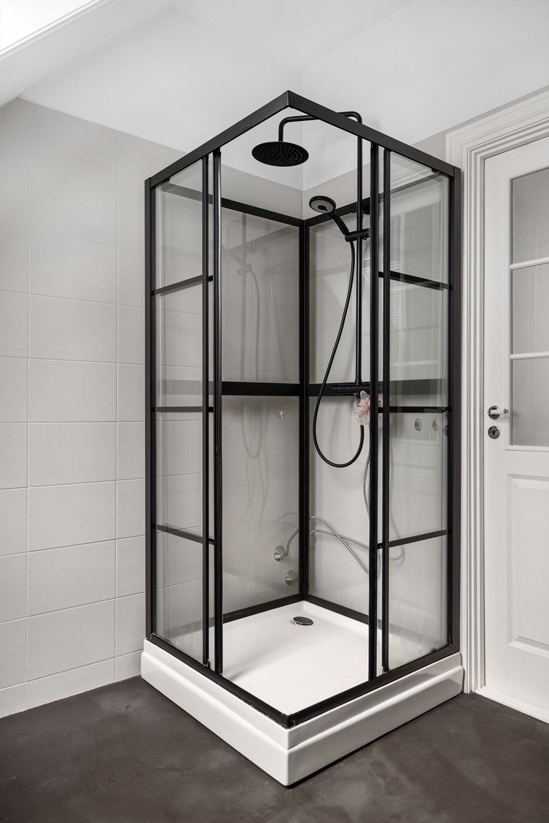 Dusjkabinett med sorte profiler som matcher de øvrige detaljene på badet. Galleribilde