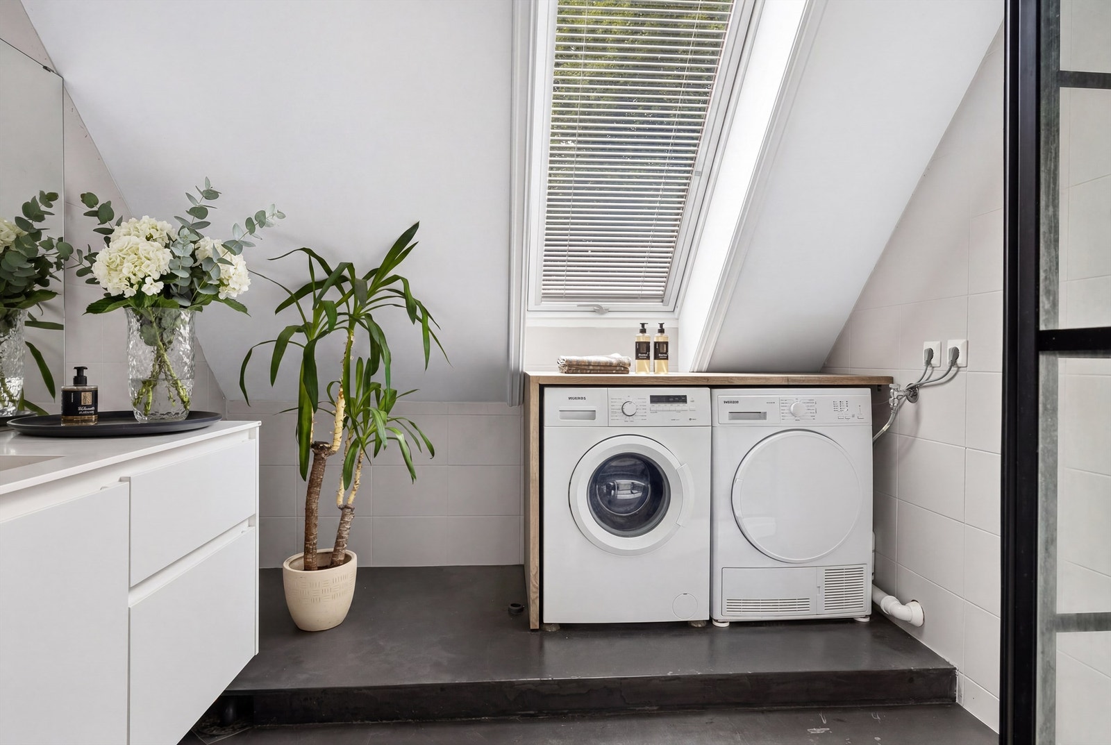 Romslig bad med praktisk nisje og opplegg for vaskemaskin og tørketrommel.
-Deler av badet var tidligere et kott som nå er innlemmet i badet. Dette er en bruksendring fra tilleggsdel til hoveddel, som er et søknadspliktig tiltak. Galleribilde