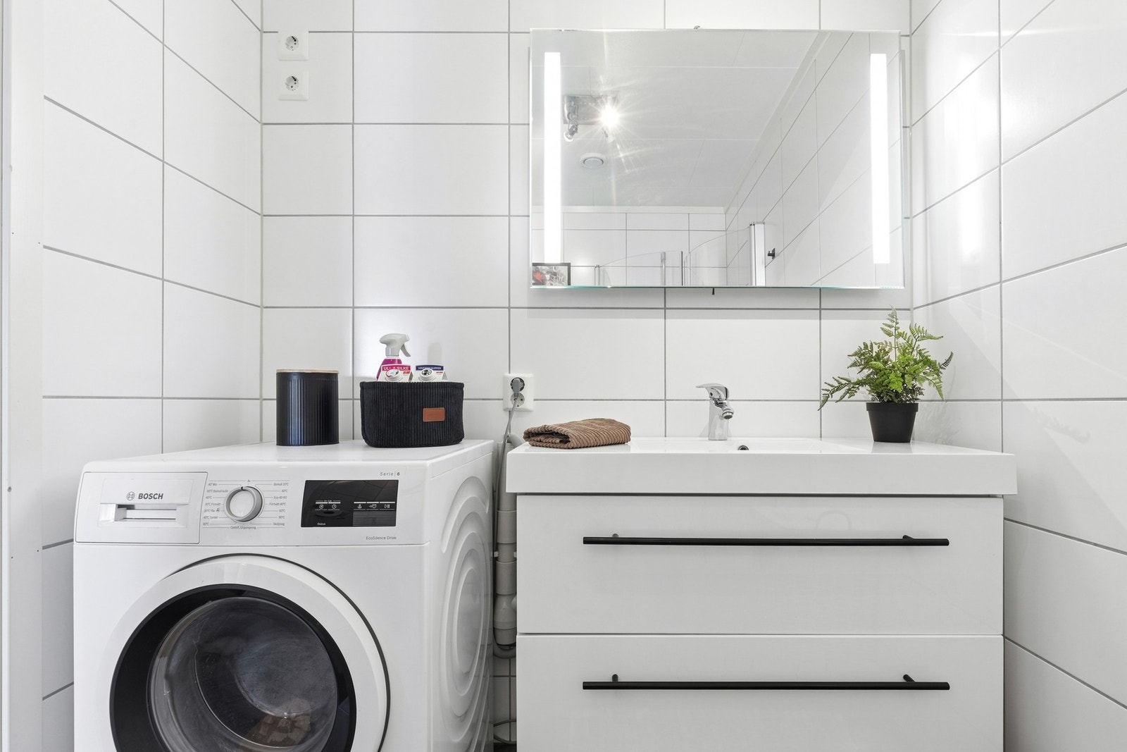 Praktisk bad med moderne innredning, opplegg for vaskemaskin og god oppbevaringsplass i servantskap. Galleribilde