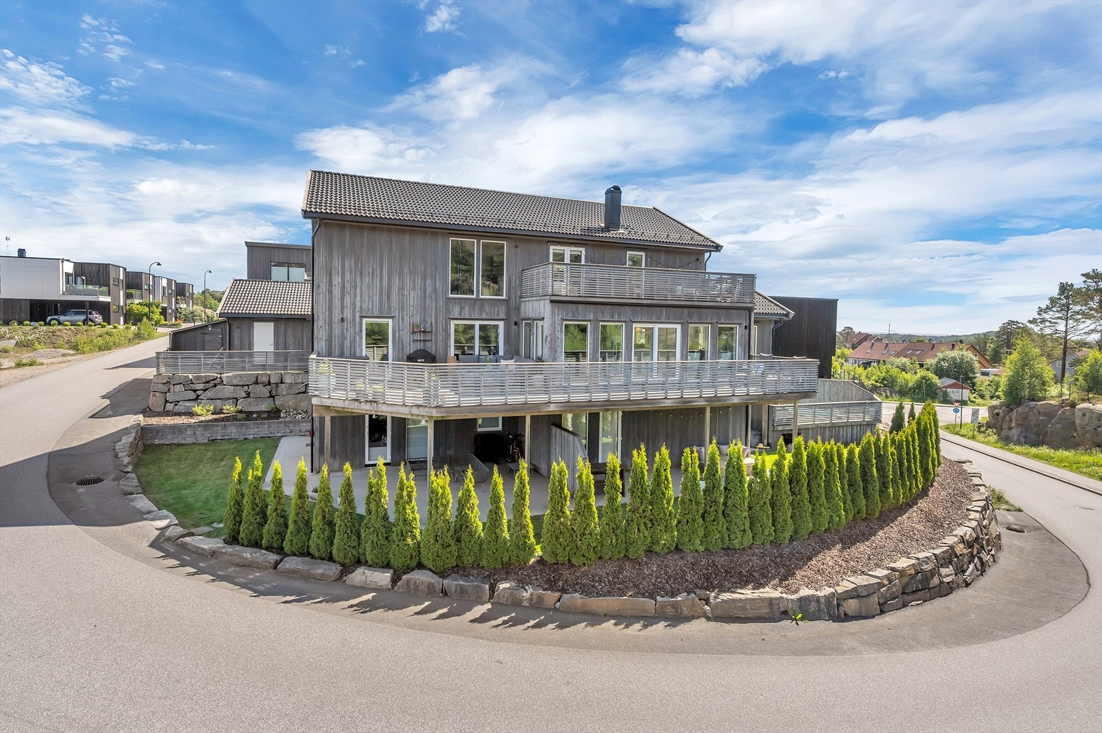 Sett fra vest tomten pent opparbeidet med mur, tujahekk, gressplen og betongplatting. Galleribilde