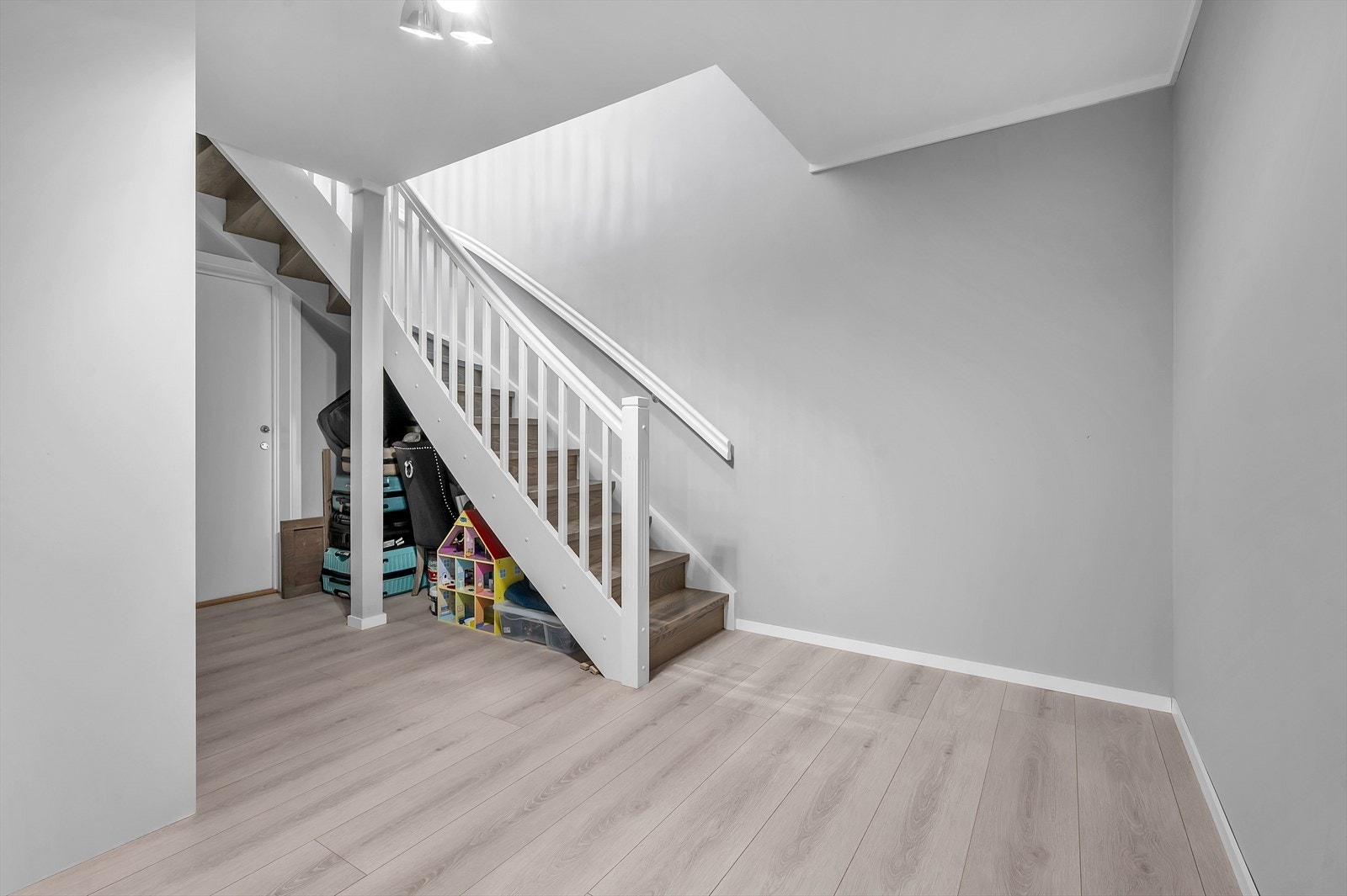 Vi har nå beveget oss helt ned i underetasjens gang som har varmekabler. Dør du ser er mot den ene innredede hybelen. Etasjens hoveddel består av 1 soverom og 1 bad. Galleribilde
