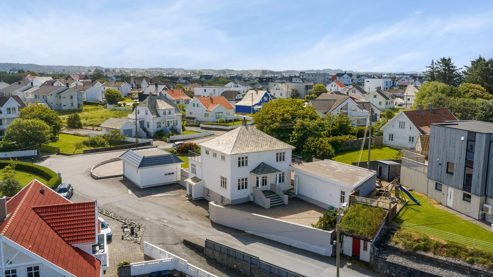 Oversikt over eiendommen med hovedhus, garasje og hagestue. Galleribilde