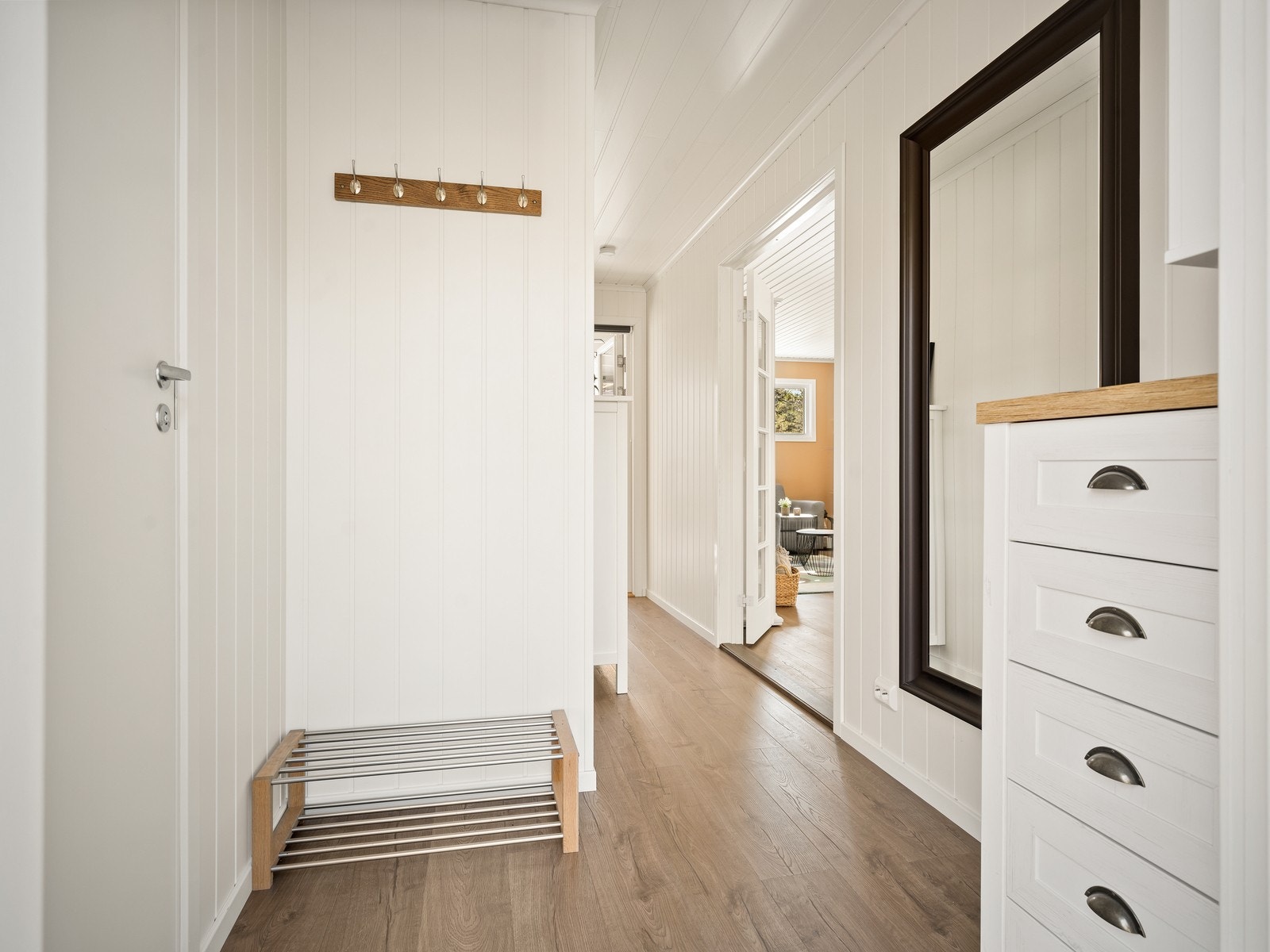 Entréen ønsker velkommen inn og gir et første inntrykk av de gjennomgående oppgraderte flatene. En tofløyet dør med glassfelt leder inn til stuen. Galleribilde