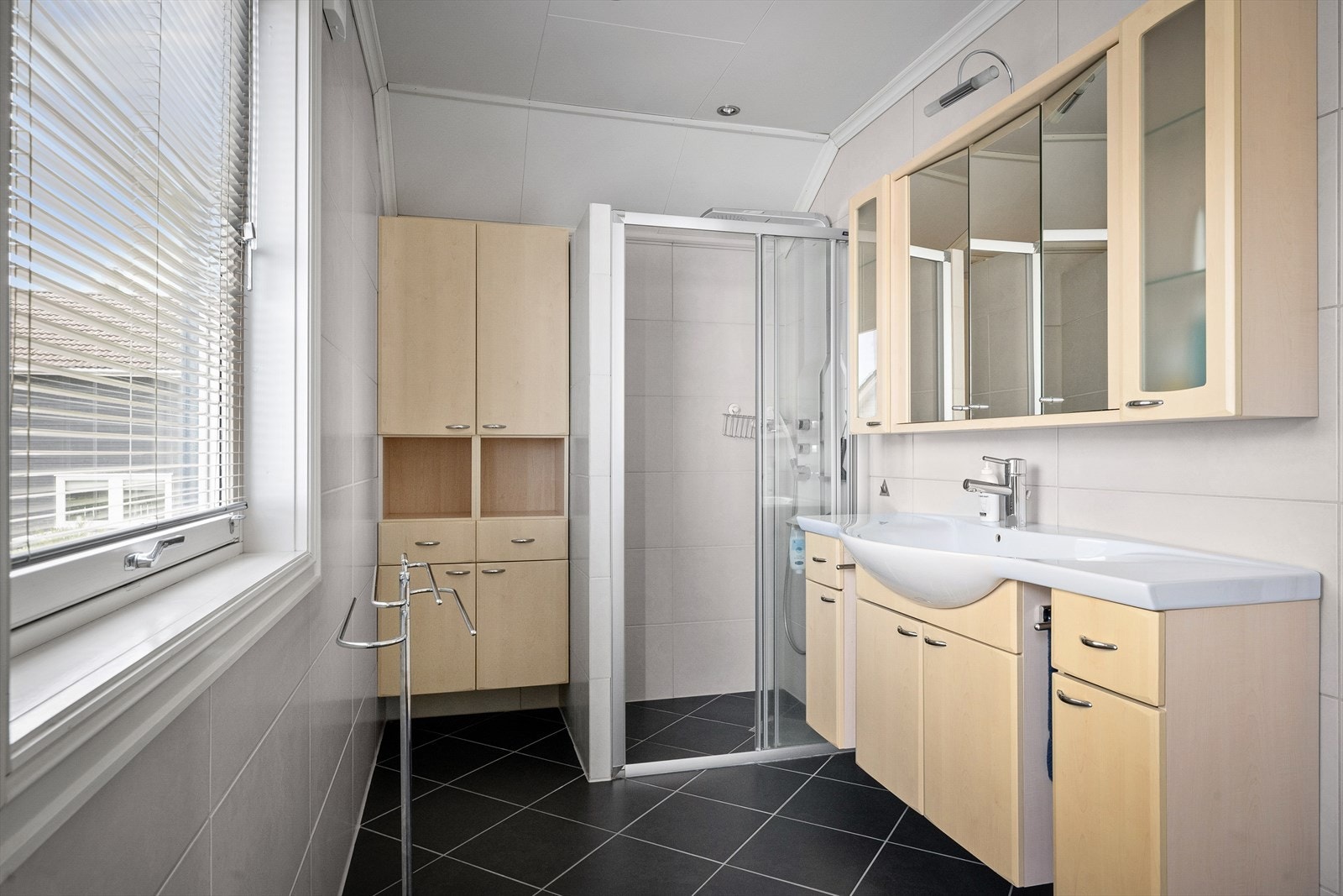 Badet er utstyrt med dusjhjørne og rikelig med skapplass. Galleribilde