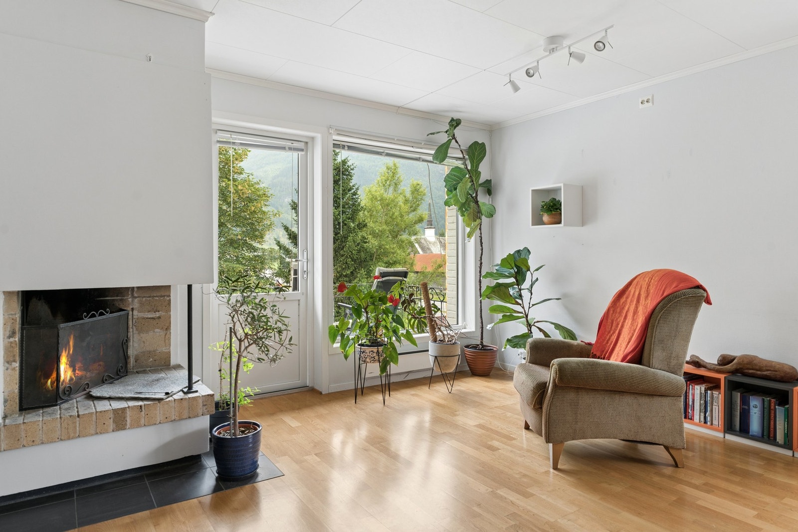 - Stuen har store vindusflater som slipper inn rikelig med naturlig lys, og peisen bidrar til en lun og behagelig varme i boligen - Galleribilde