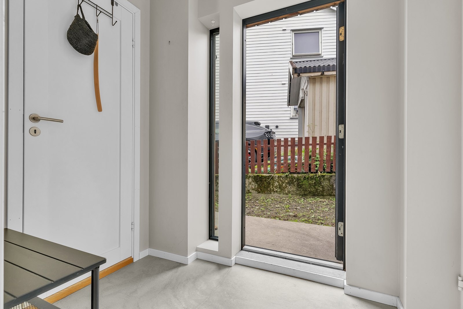 Lys entré med malte, glatte flater og flytbetong på gulv. Galleribilde