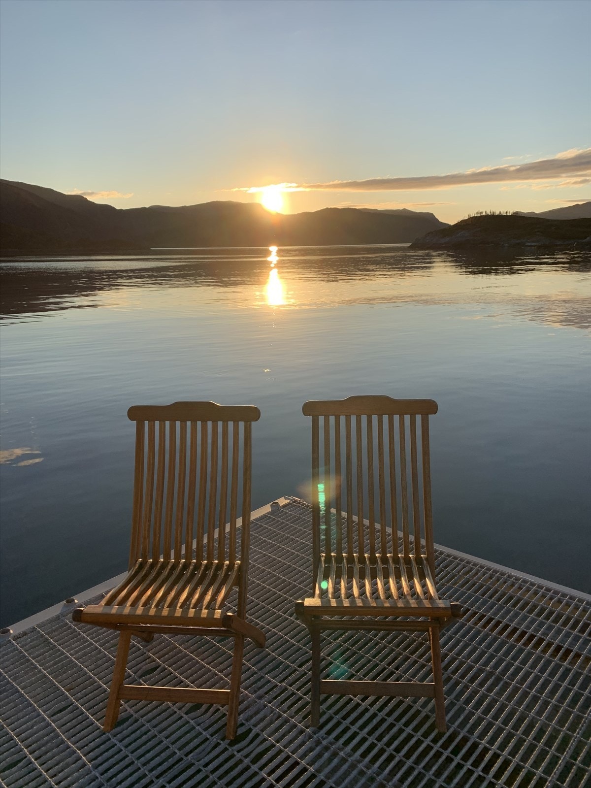 Nokre stader treng ikkje mange ord. Berre to stolar, ei bryggje og utsikt mot fjord, fjell og ei sol. (Selgars eige bilete) Galleribilde