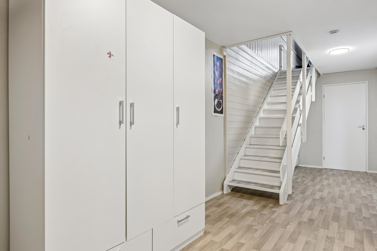 Hall på 14,3 m² binder sammen soverommene i sokkelen. God plass til oppbevaring, trapp opp til stueplanet. Galleribilde
