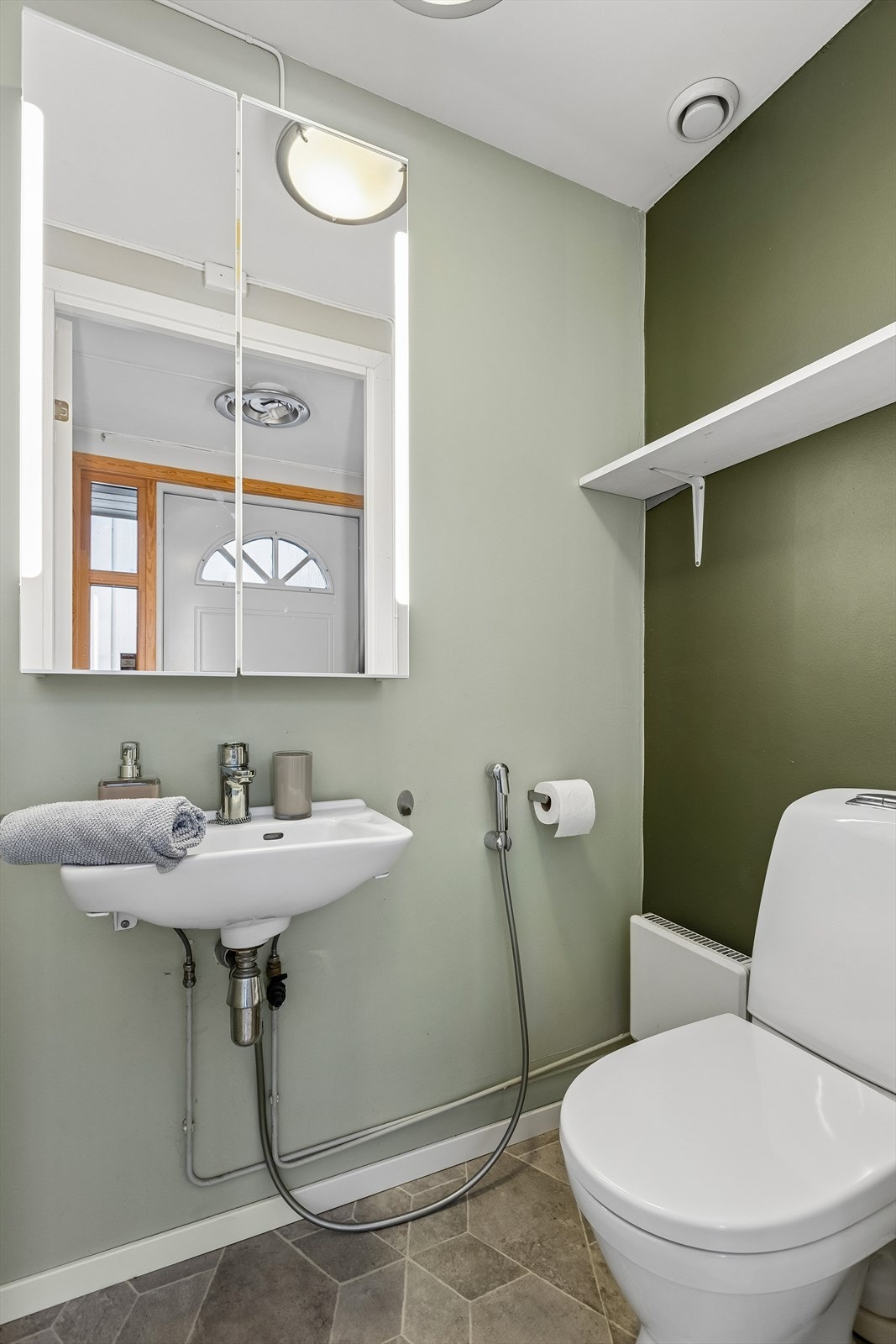 Separat toalett på 1,2 m² i tillegg til badet, med servant og speilskap. Galleribilde