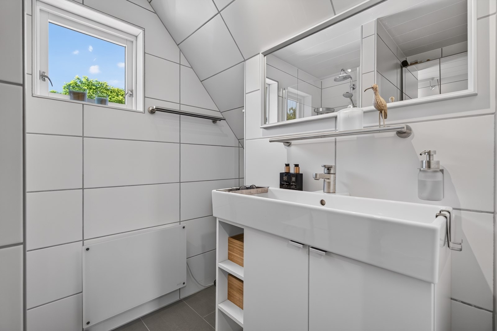 Badet i andre etasje har flislagte vegger og servant med underskap. Galleribilde