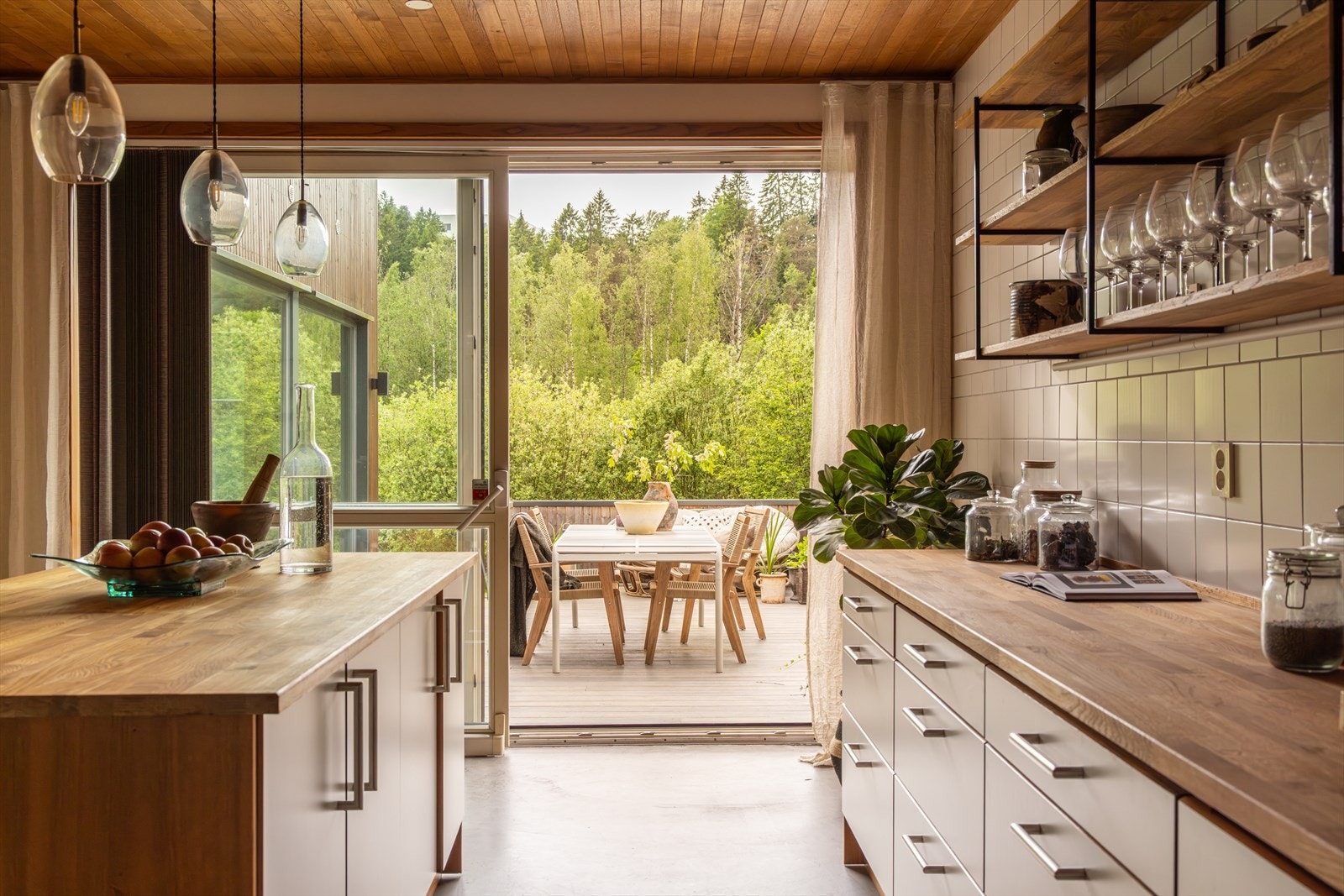 Fra kjøkkenet er det direkte utgang til en av boligens flere terrasser, perfekt for måltider og hyggelige stunder utendørs. Galleribilde