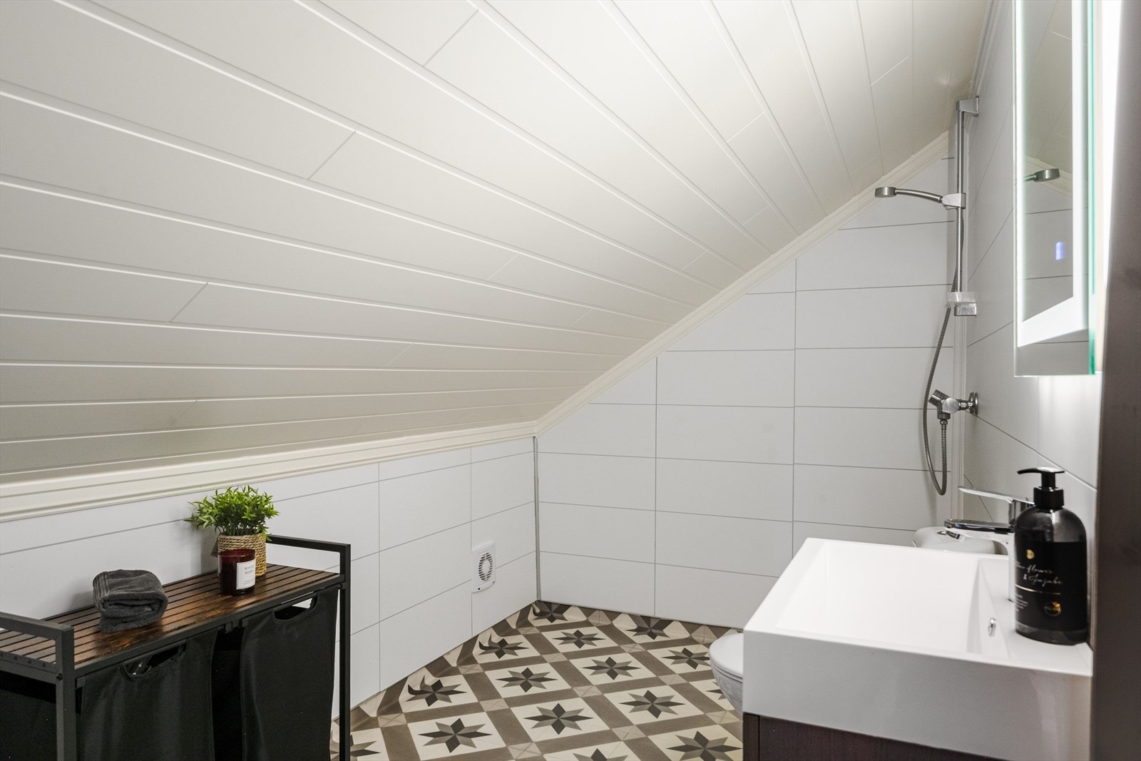 Dette badet ble pusset opp i 2020 og har baderomsplater på veggene og belegg på gulvet med panelovn på varmekilde. Galleribilde