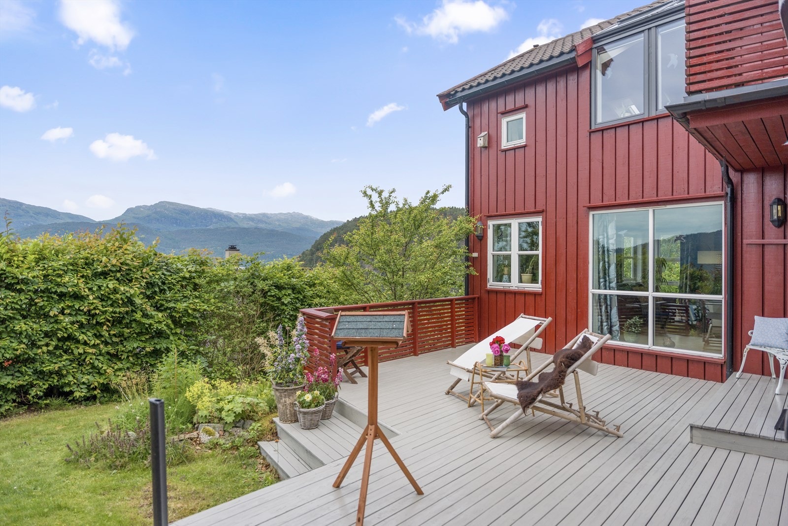 Stor treterrasse og en usjenert tomt med frodig beplantning. Gode solforhold. Galleribilde