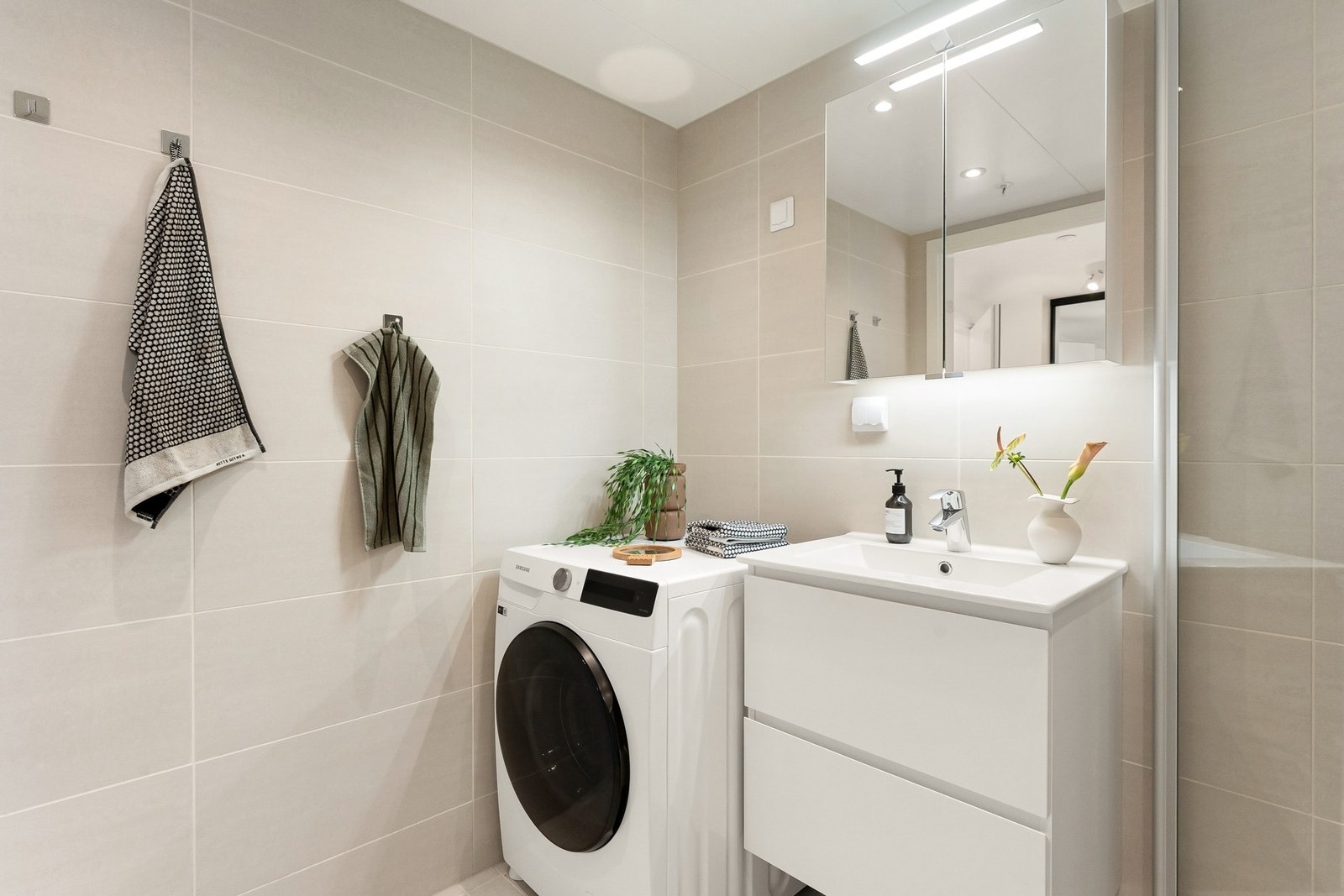 Det er praktisk opplegg for vaskemaskin, og innkassingen er utført med drenering. Badet har avtrekk tilkoblet byggets balanserte ventilasjonsanlegg. Galleribilde