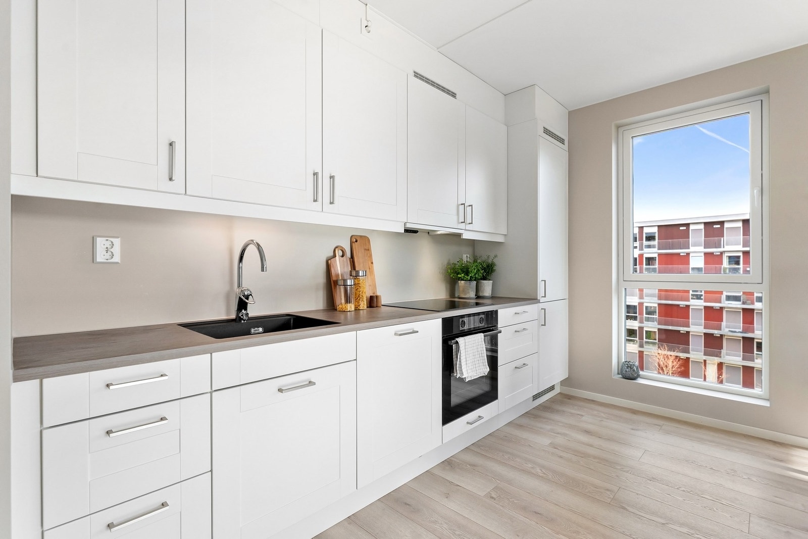 Kjøkkenet er stilrent med slette, hvite fronter og godt med både skap- og benkeplass. Galleribilde